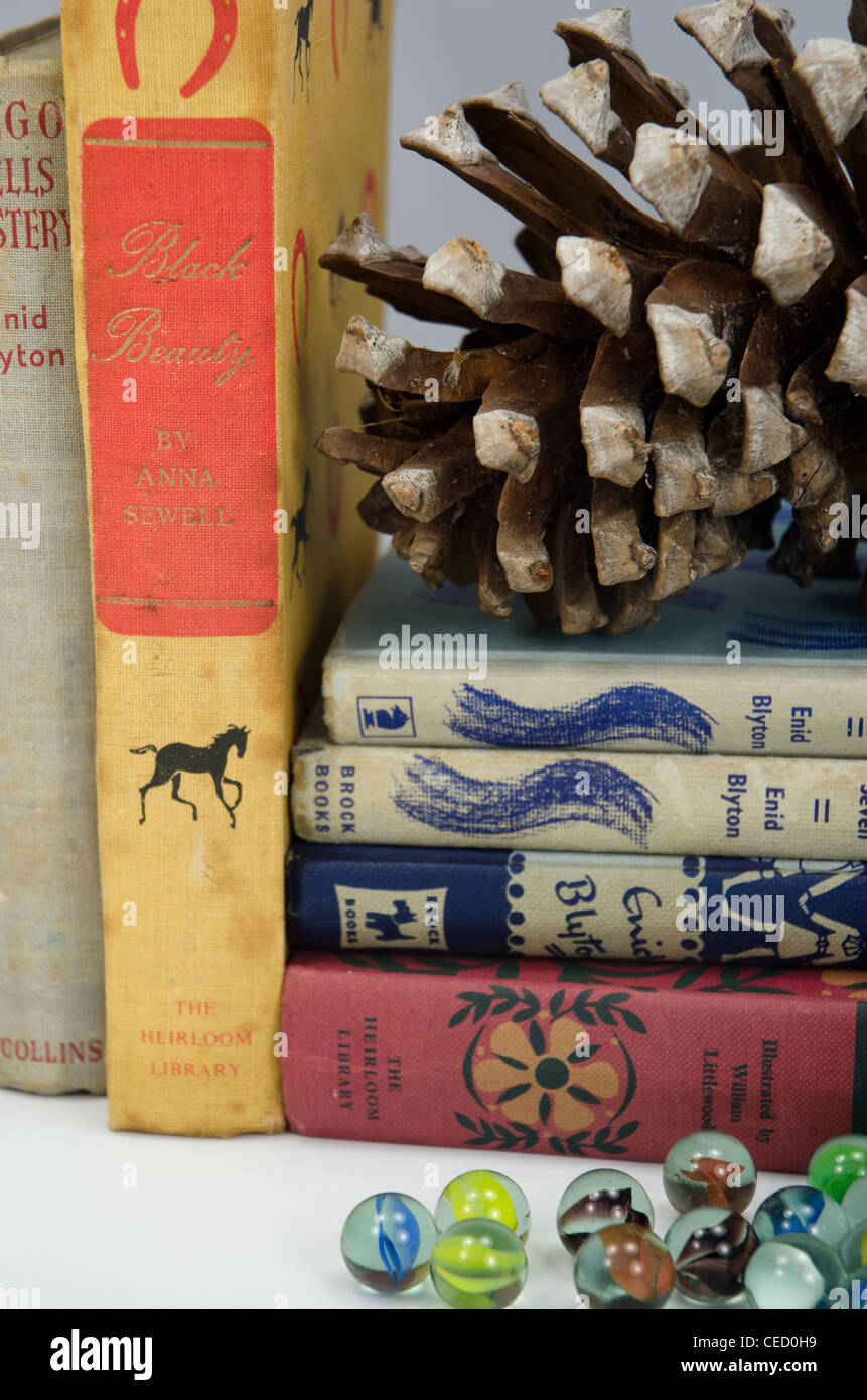 Vintage juegos libros de tapa dura y un tarro de canicas en una estantería de madera Foto de stock