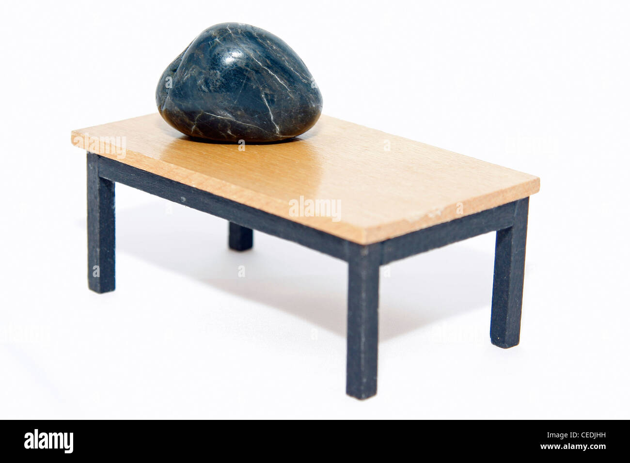 Cerca de una piedra acostado sobre una mesa en miniatura Foto de stock
