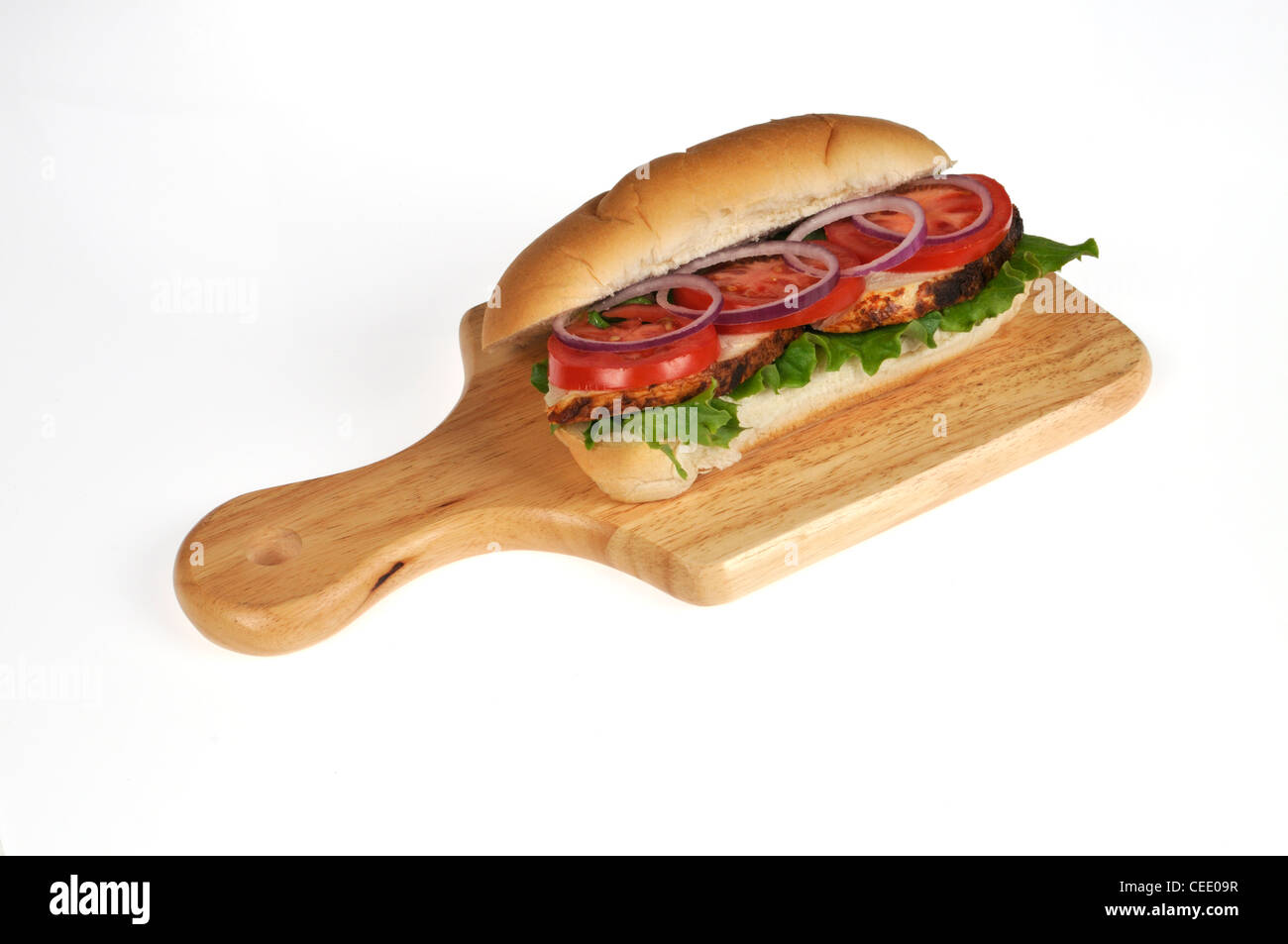 Asador de pollo sándwich submarino con lechuga, tomate y cebolla ensalada de madera deli junta sobre fondo blanco. Foto de stock