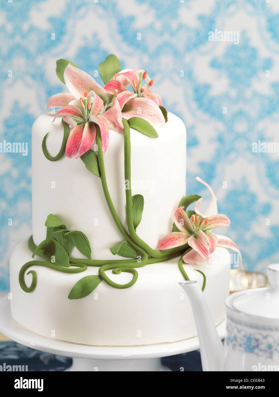 Fancy tarta decorada con lirios sobre una mesa Foto de stock