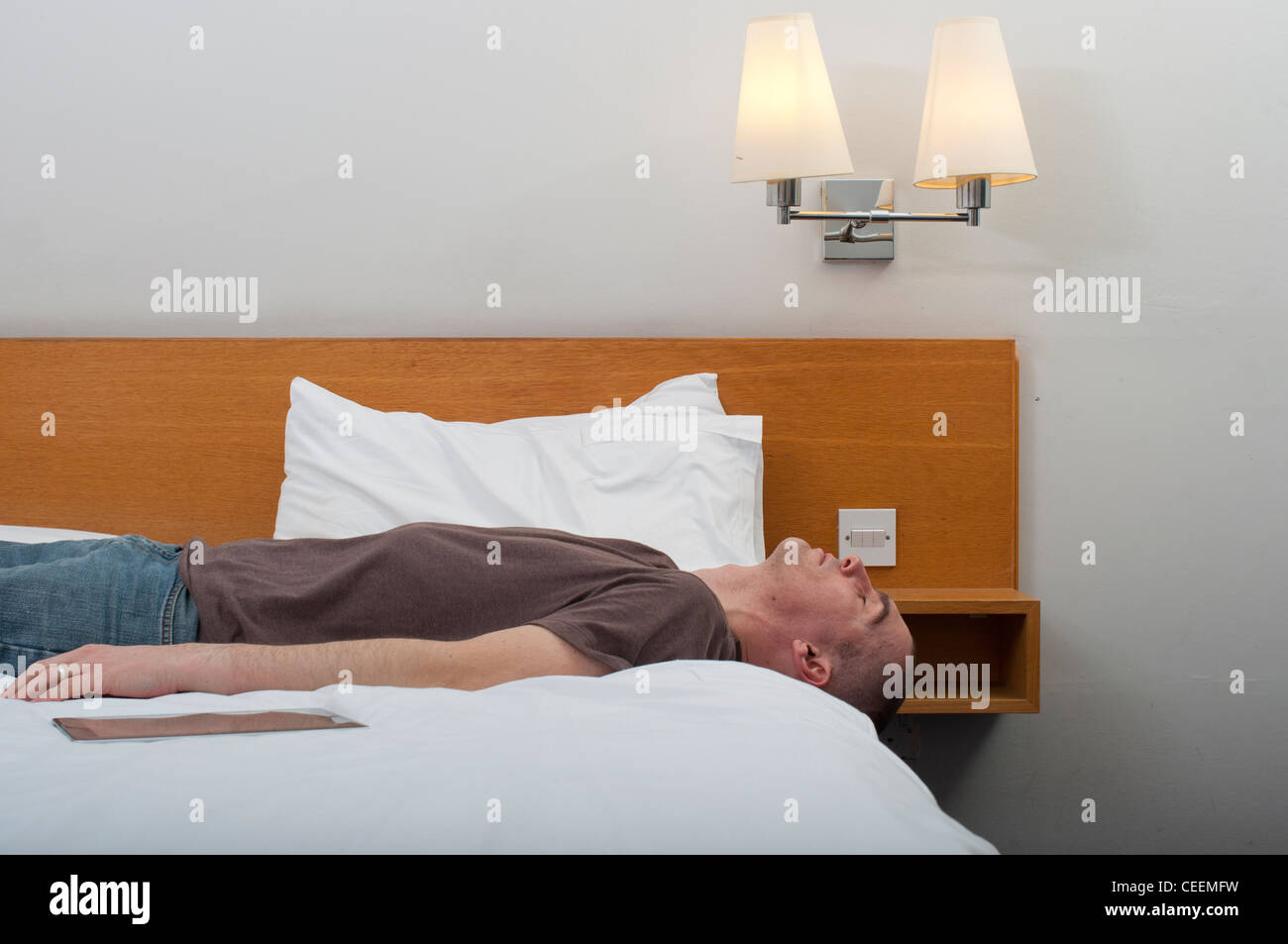Hombre, 30-40 años, con ipad en una habitación de hotel. Foto de stock