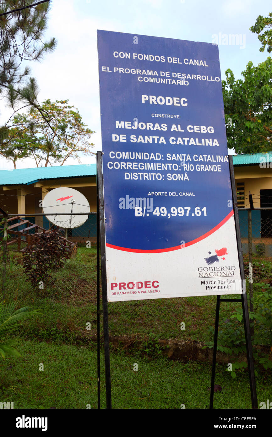 Firmar fuera de la escuela promoviendo proyectos de desarrollo financiados por pagos del Canal de Panamá, Santa Catalina, Provincia de Veraguas, Panamá Foto de stock