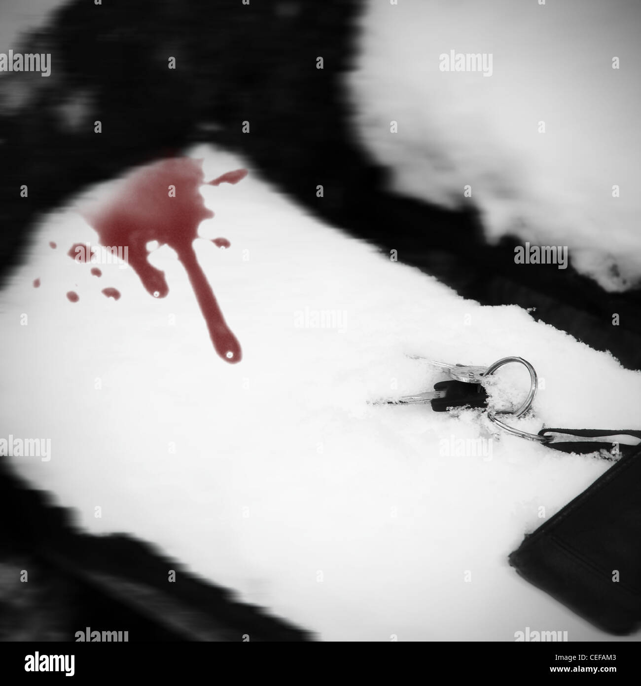 Llavero en un banco de nieve con gotas de sangre Foto de stock