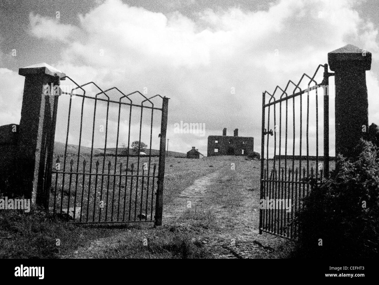 Co Clae Irlanda - Una puerta abierta y un carril camino hacia una casa en ruinas Foto de stock