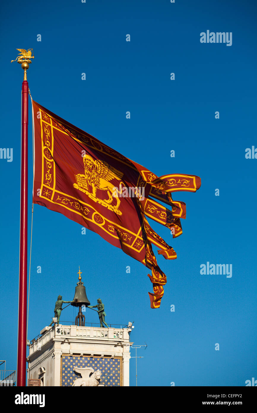 La bandera veneciana con la Torre Dell'Orologio debajo. Venecia, Italia. Foto de stock