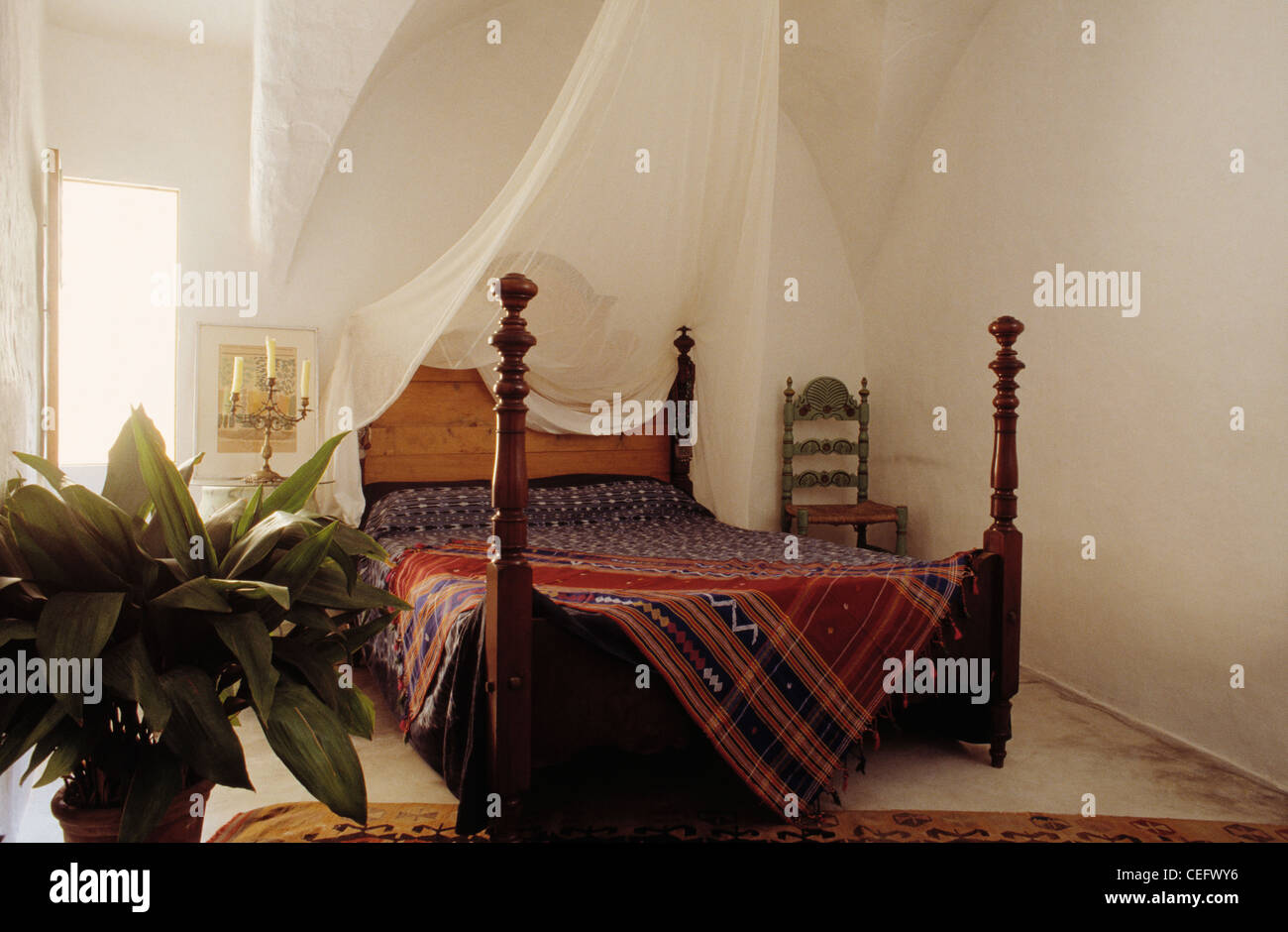 Mosquitero blanco encima de la cama tradicional mallorquina con husillo de  madera tallada y puestos tejida localmente throw en dormitorio blanco  Fotografía de stock - Alamy