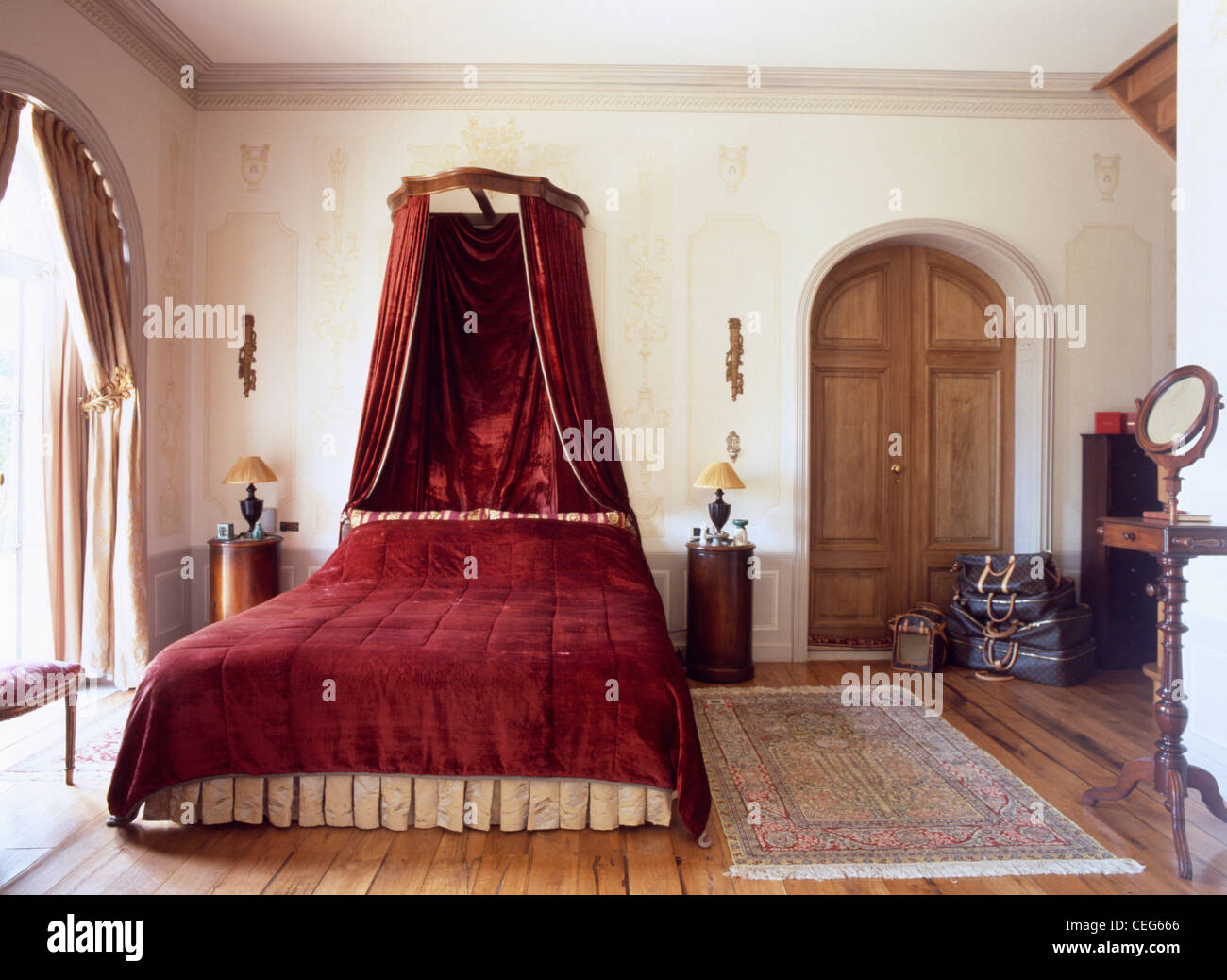 Estilo Dormitorio con cama de matrimonio con cabecero de madera y panel  rojo toile Juoy cortinas Fotografía de stock - Alamy