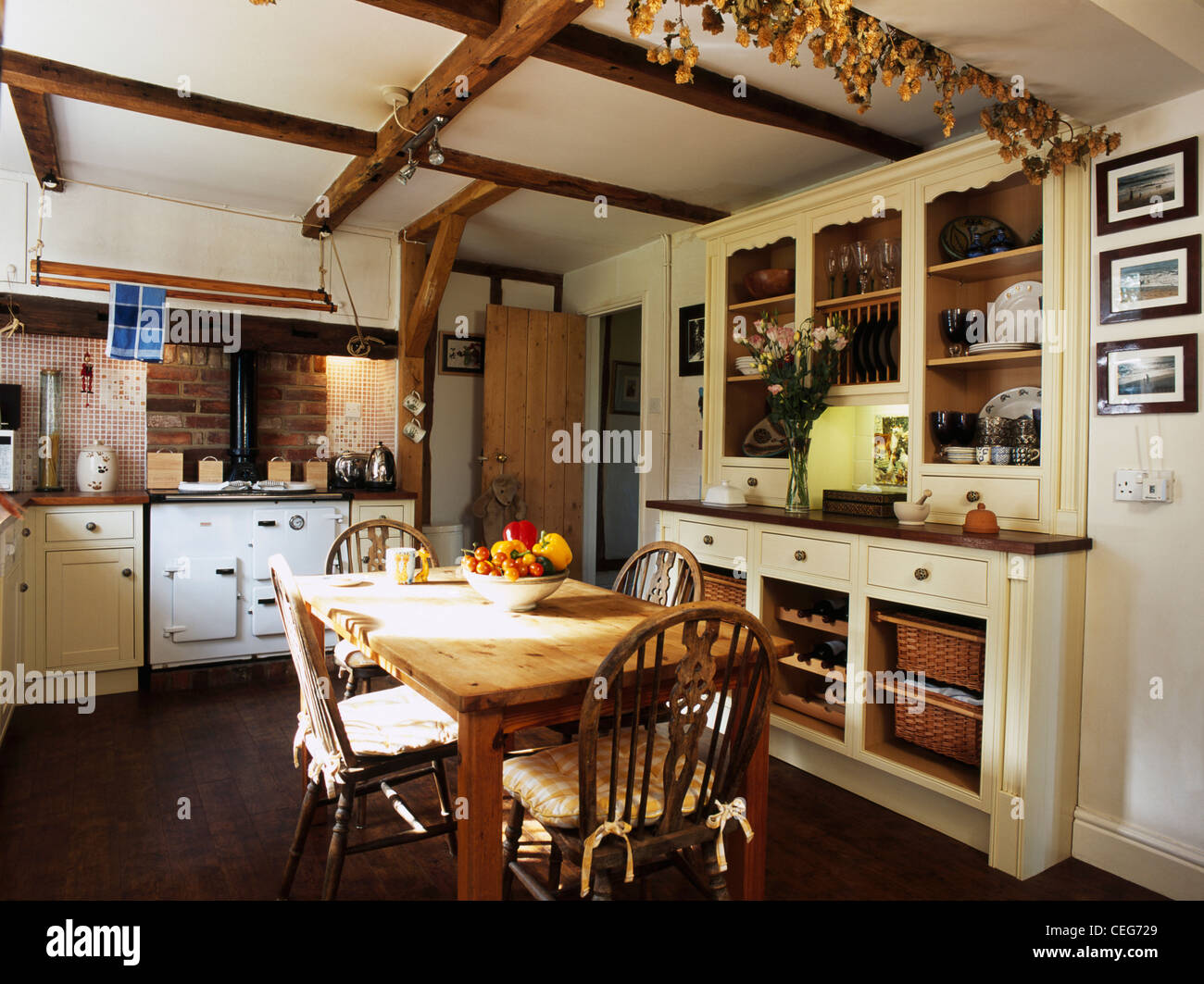 Aga blanco crema y equipado en el país aparador cocina con mesa de madera  de pino y sillas de Windsor Fotografía de stock - Alamy