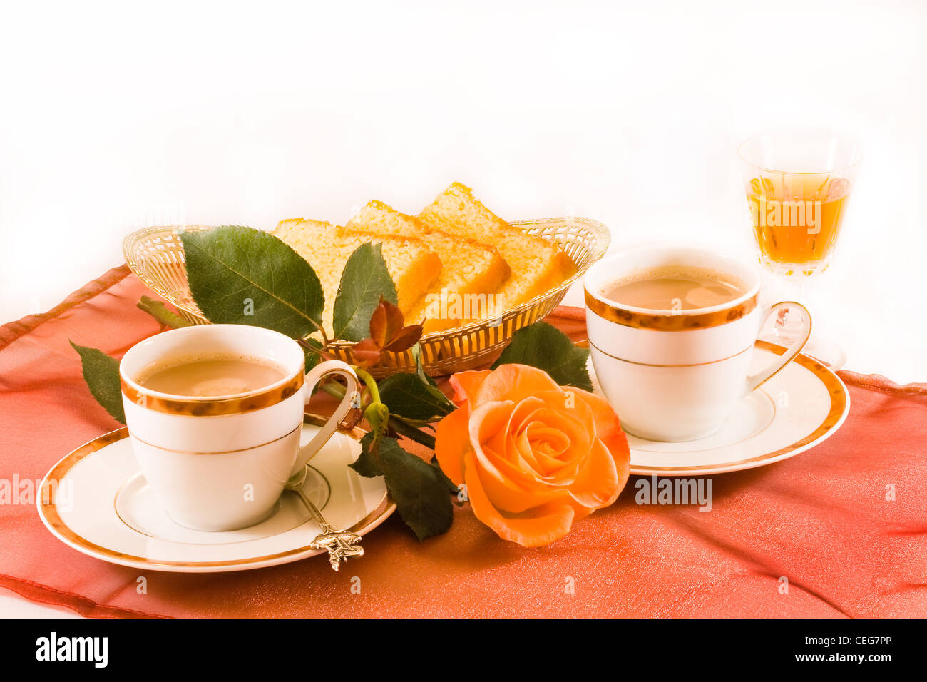 Dos tazas de café con torta y un vaso de Amaretto licor Foto de stock