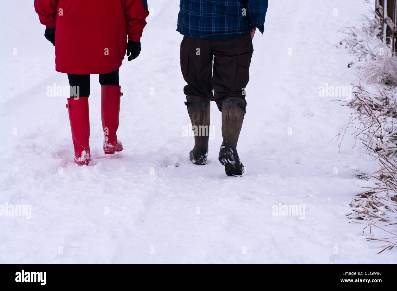La gente par Vista trasera de caminar por la nieve vistiendo botas  Wellington invierno UK Fotografía de stock - Alamy