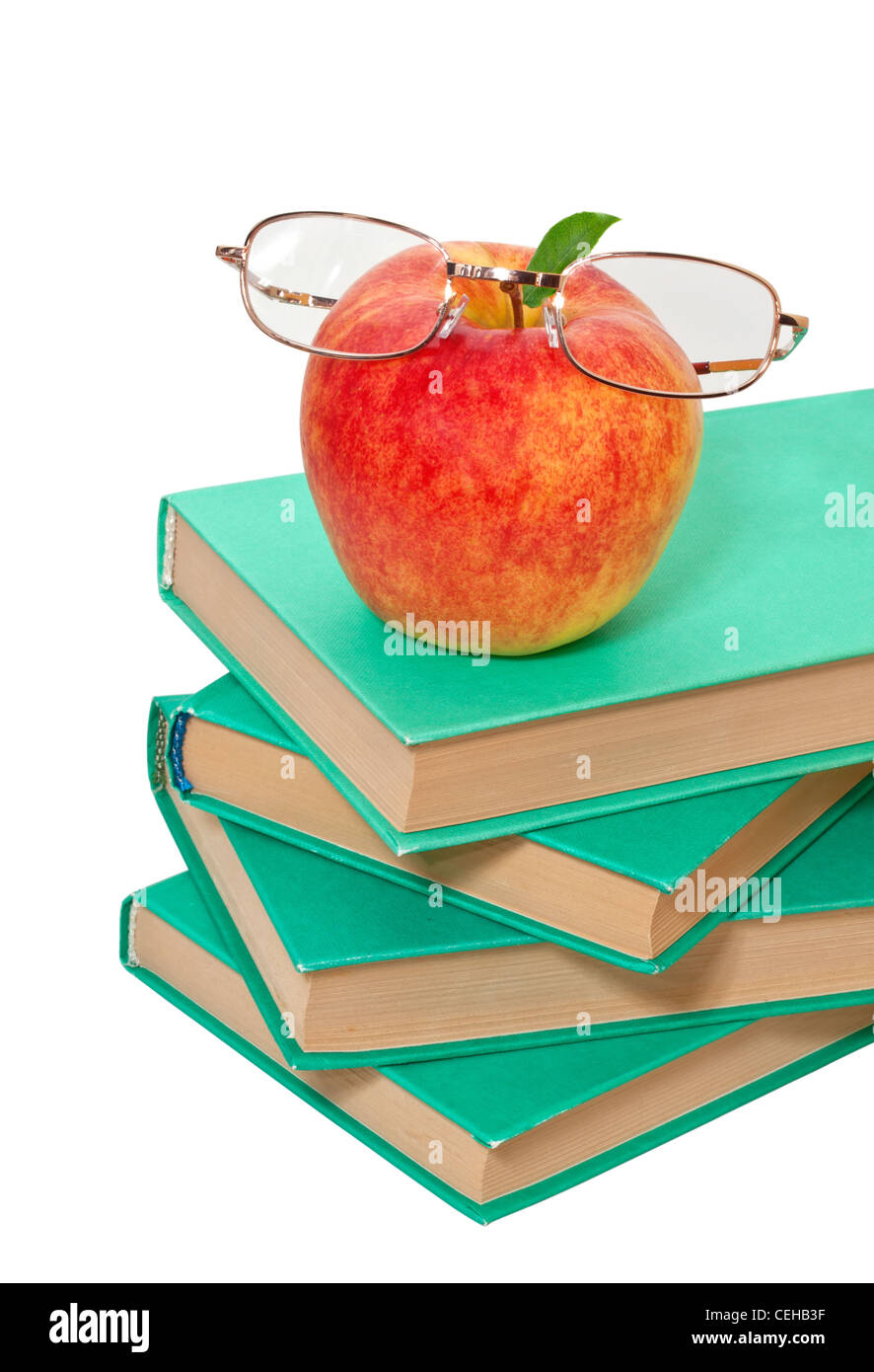 Pila de libros con una manzana y gafas sobre un fondo blanco Fotografía