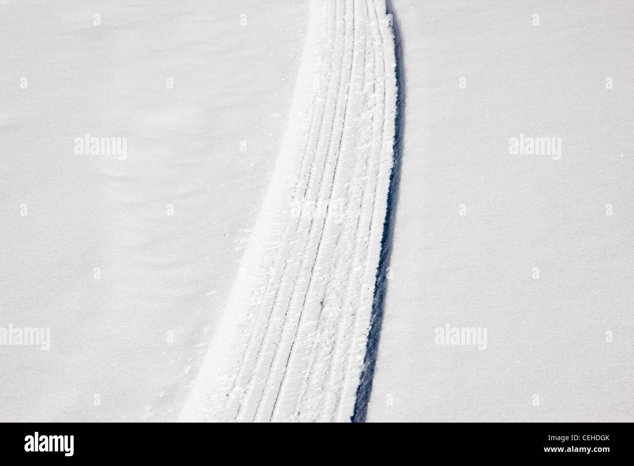 Las huellas de los neumáticos frescos en una carretera de montaña cubiertas de nieve cerca de Monarch Pass, Chaffee County, Colorado, EE.UU. Foto de stock