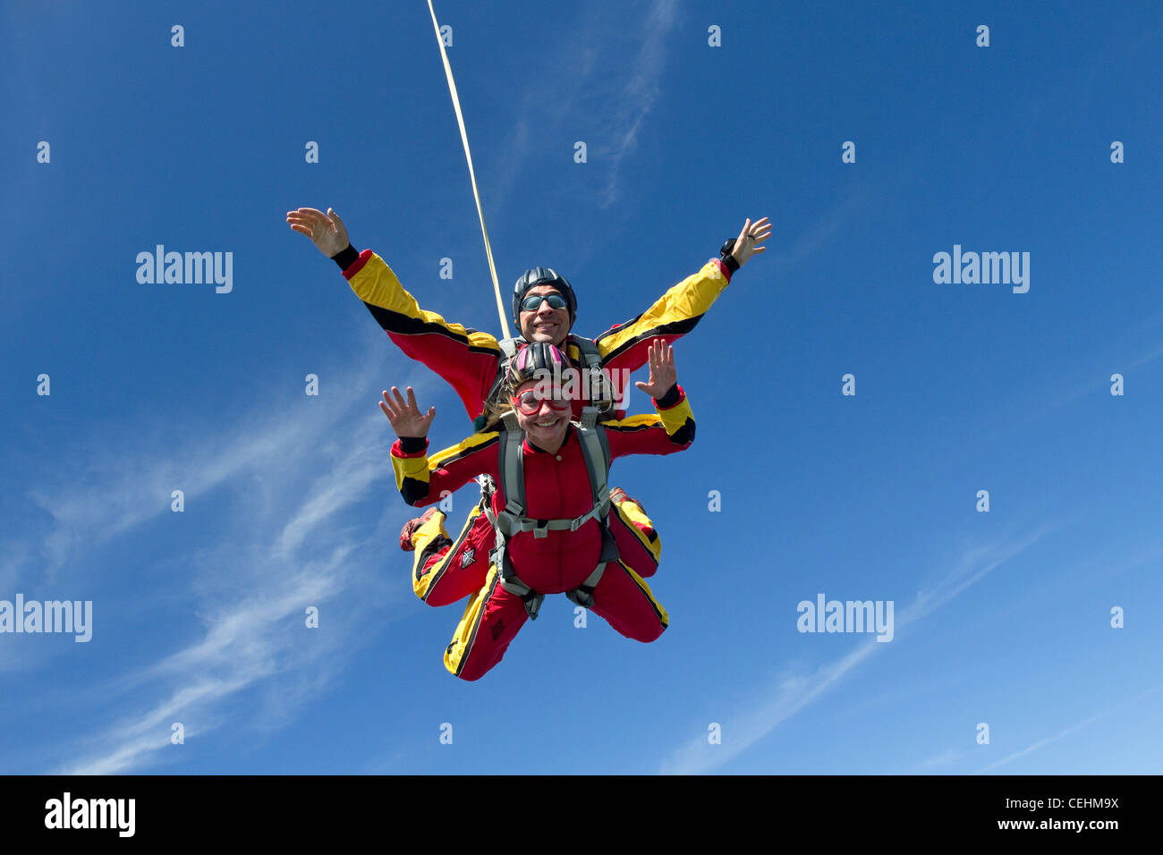 Tandem skydivers par se divierten juntos en el cielo azul. Ideal para ver la emoción de este deporte de aventura de RUSH. Foto de stock