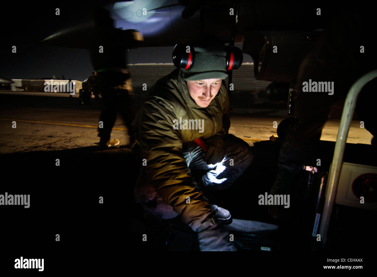 Tecnología de la Fuerza Aérea de EE.UU. SGT. Sean Latimer, un jefe de la tripulación de F-16C Fighting Falcon, realiza el mantenimiento de un avión el 14 de febrero de 2012. Latimer está asignado al escuadrón de Mantenimiento de aeronaves Expedicionarias 455, y se despliega desde el 177º ala de combate, la Guardia Nacional Aérea de Nueva Jersey. Foto de stock