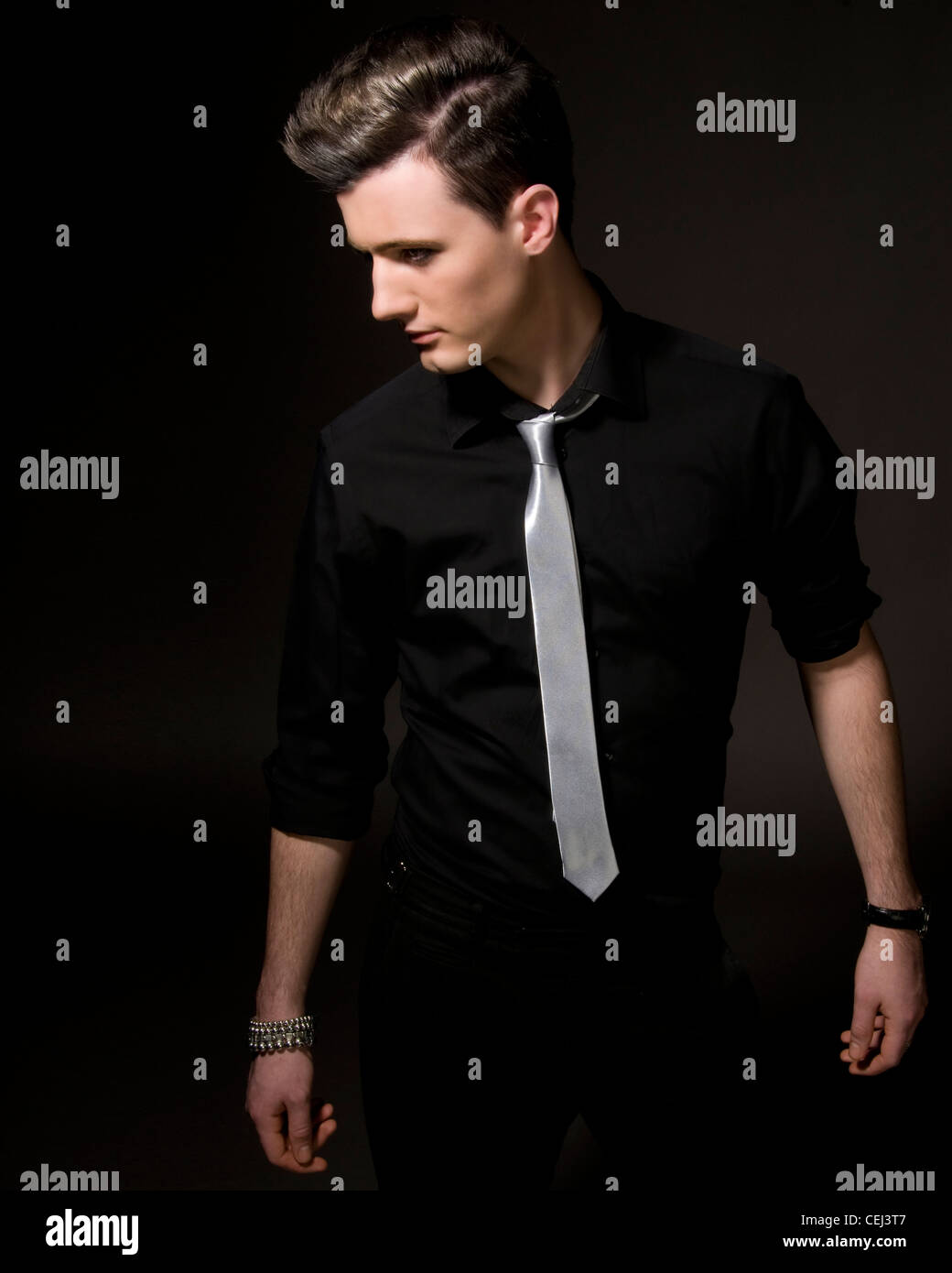 Modelo masculino en studio negro camisa y corbata de plata Fotografía de  stock - Alamy