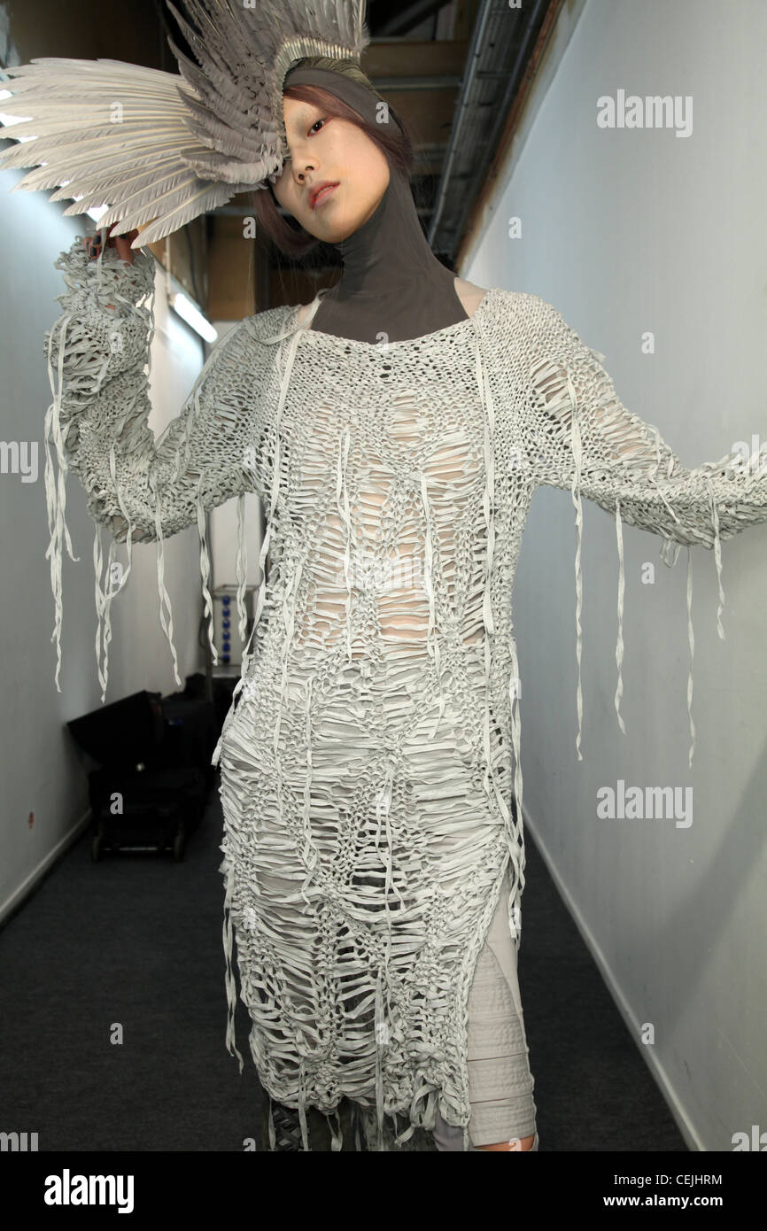 Gareth Pugh Backstage París listo para Primavera Verano Mujer vistiendo traje gris rallado con sombreros de plumas Fotografía de stock - Alamy