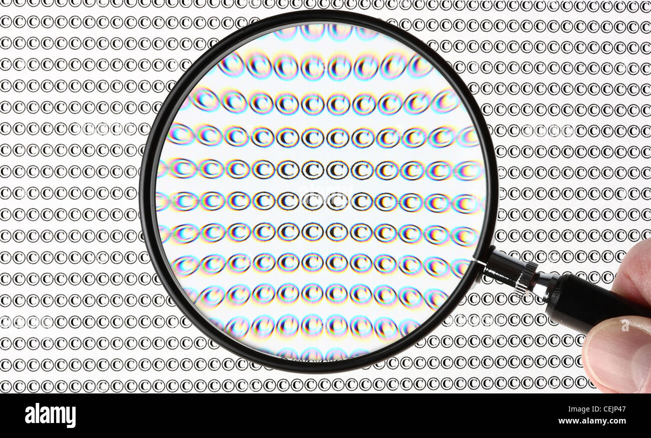 Lupa resaltando el signo de copyright, el símbolo ©. Imagen simbólica. Foto de stock