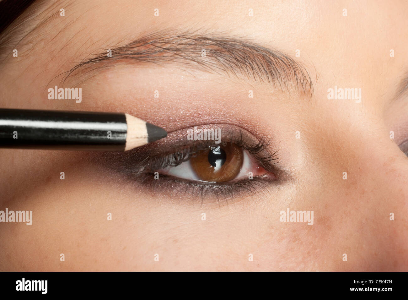 Maquillaje paso a paso aplicando hembra negro lápiz delineador de ojos a su  párpado superior Fotografía de stock - Alamy