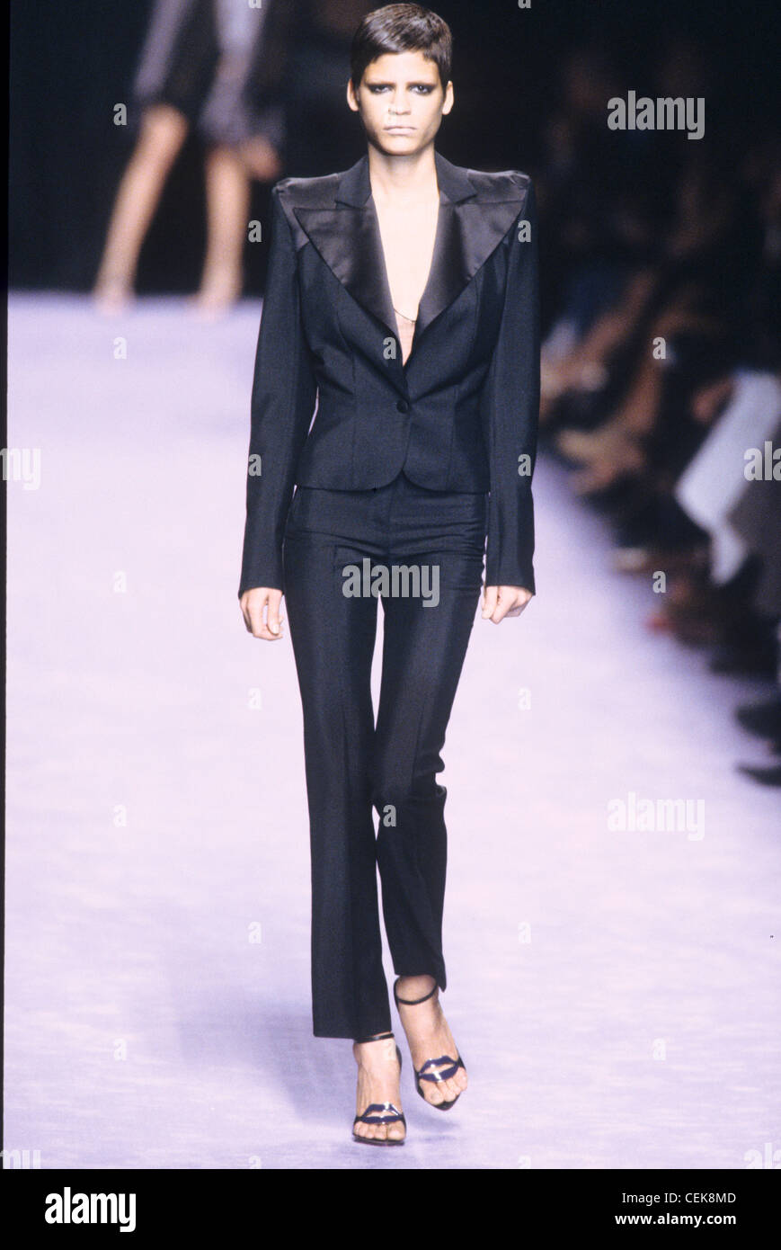 Yves Saint Laurent Primavera Verano Mujer vistiendo traje pantalón slim  negro con solapas de satén Fotografía de stock - Alamy