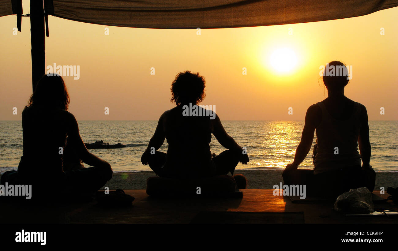Yoga y meditación al atardecer en la playa de Patnem Palolem, Goa (por la playa), India Foto de stock
