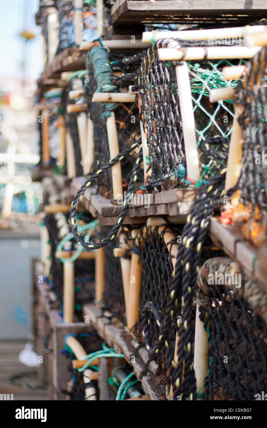 Langosta, cangrejo y redes de pesca y ollas apilados vacíos y listos para su uso por los pescadores en la industria pesquera. Foto de stock