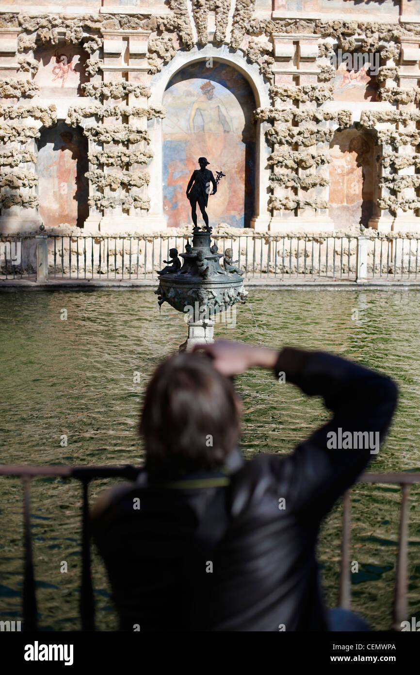 Un joven toma una foto en los Jardines del Alcázar de Sevilla Foto de stock