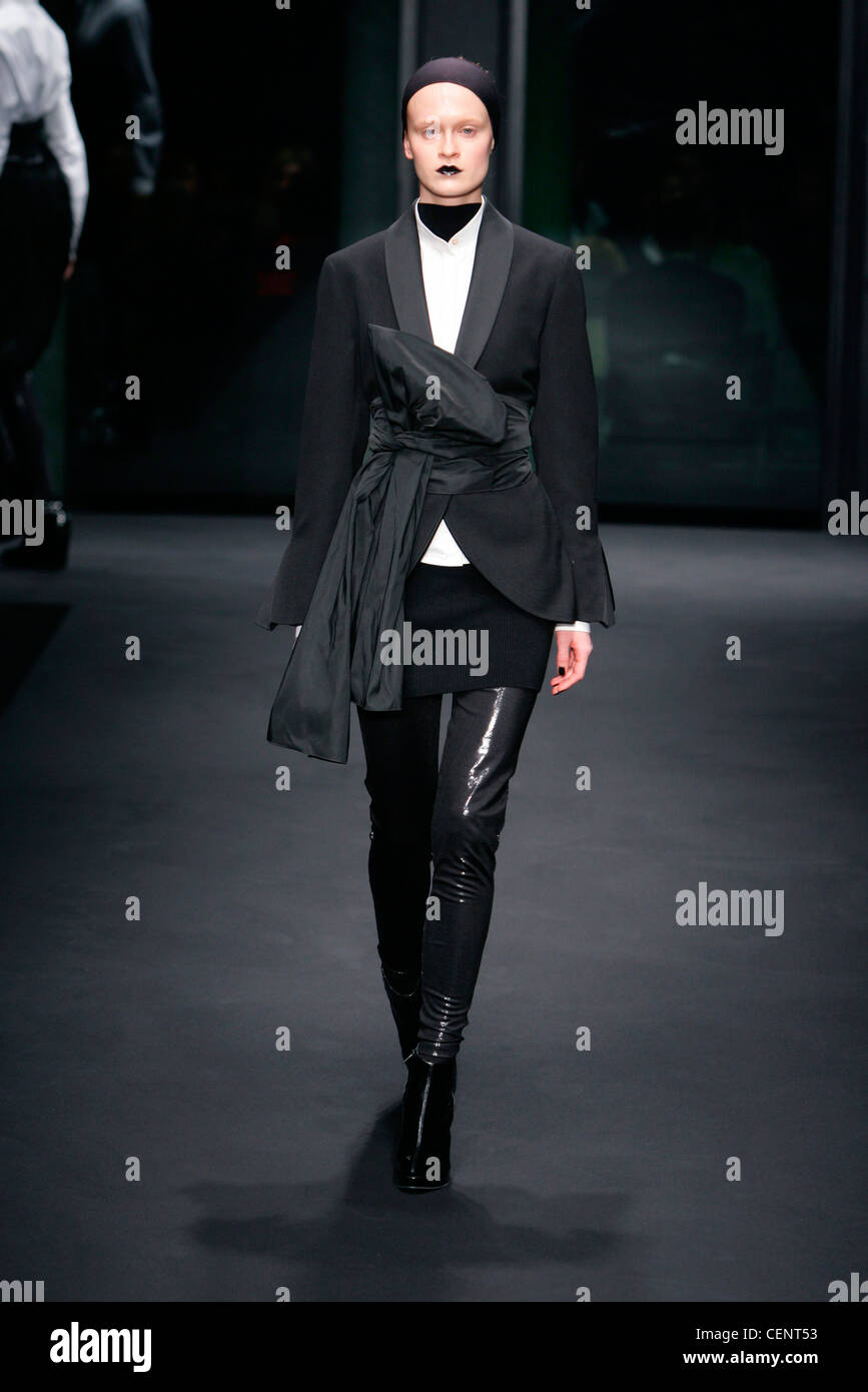 Todo negro esmoquin gran lazo bow Correa, camisa blanca falda corta más  skinny pants botines de gamuza, diadema y negro Fotografía de stock - Alamy