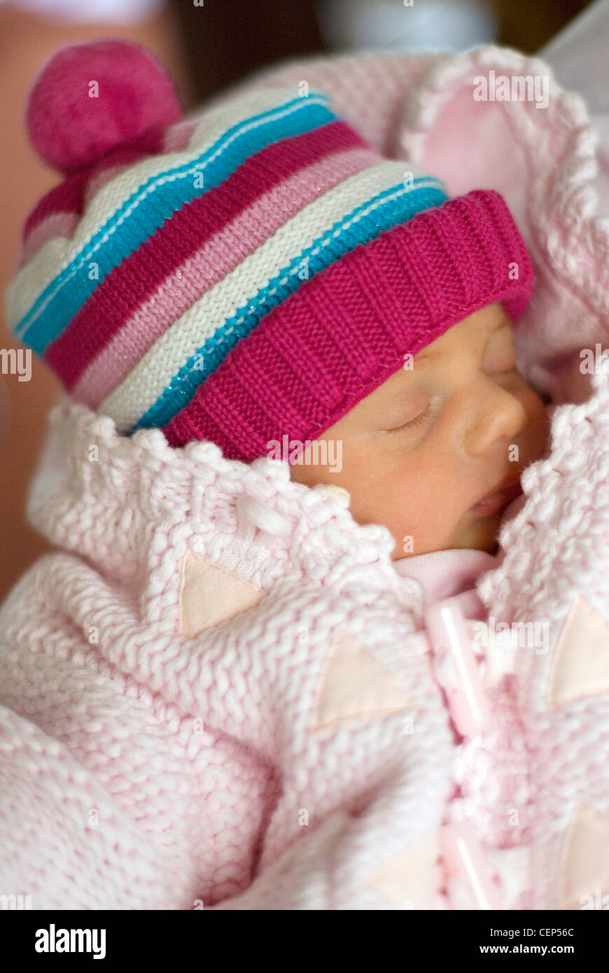 Un bebé recién nacido femenino vestido con un puente de tejido rosa rosa y  rayas tejidas hat, durmiendo Fotografía de stock - Alamy