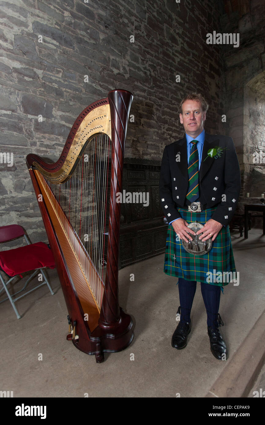 Un hombre escocés pecado un tradicional falda está junto a un arpa, un  instrumento tradicional utilizado en Escocia Fotografía de stock - Alamy