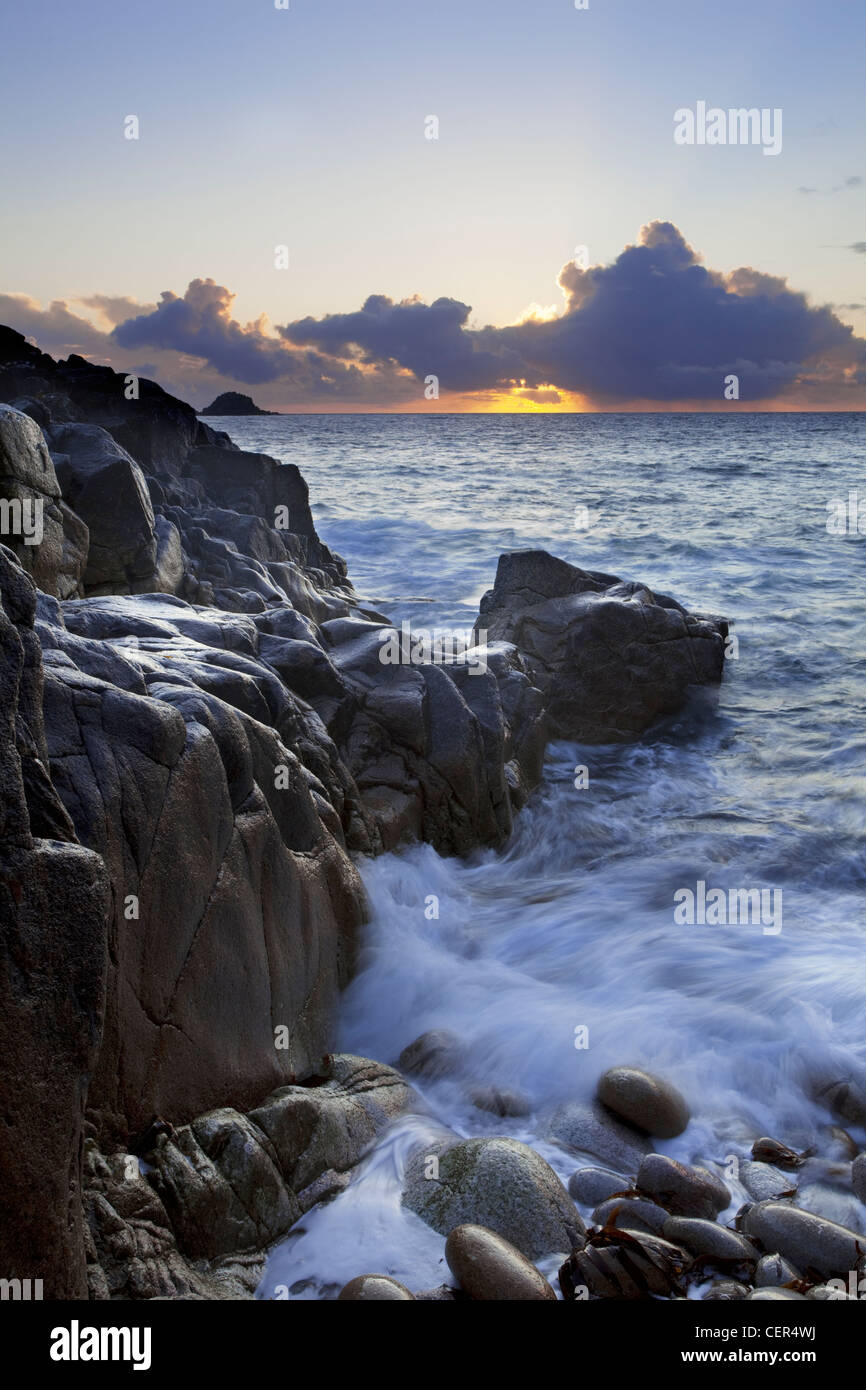 La puesta de sol sobre el mar visto desde Porth Nanven, una playa conocida a veces como 'Dinosaur Playa huevo" debido al gran depósito de Foto de stock