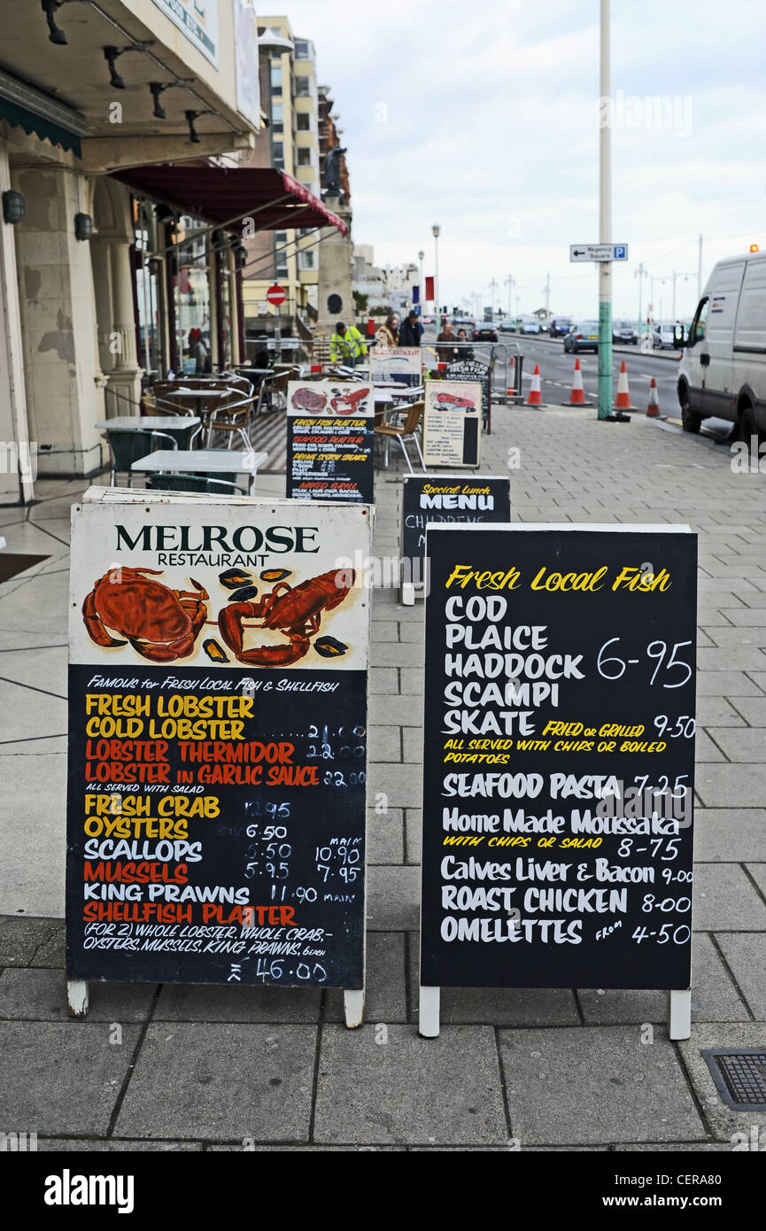 Los menús de los restaurantes de pescado de Melrose fuera en el pavimento de Brighton Seafront UK Foto de stock