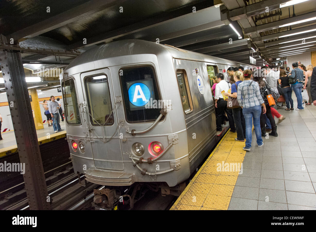 La gente de embarcar en el tren de una línea de metro de Nueva York, Ciudad de Nueva York, EE.UU. Foto de stock
