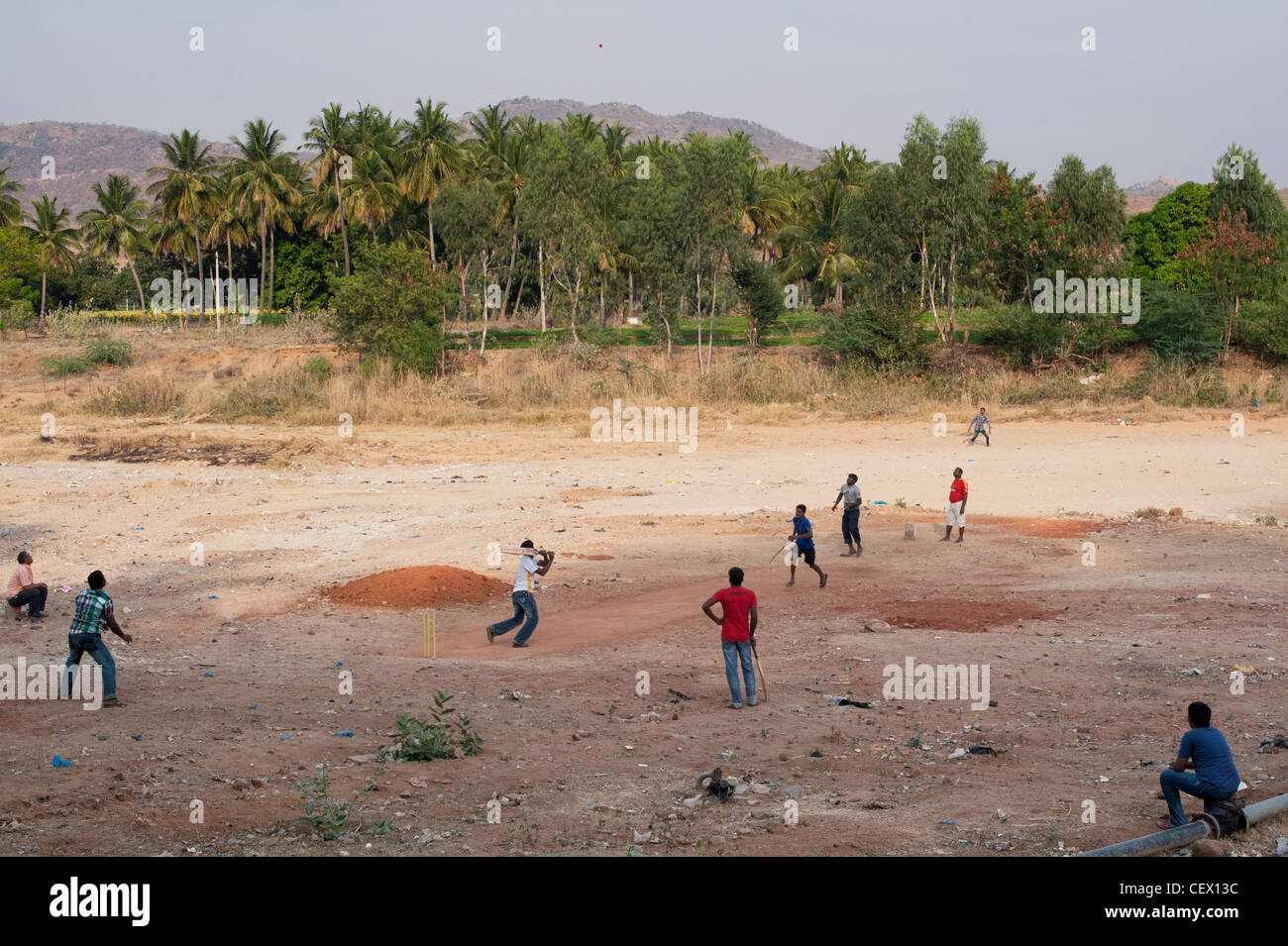 Indian muchachos jugando críquet en el lecho seco de un río en la ciudad india de Puttaparthi rural, Andhra Pradesh, India Foto de stock