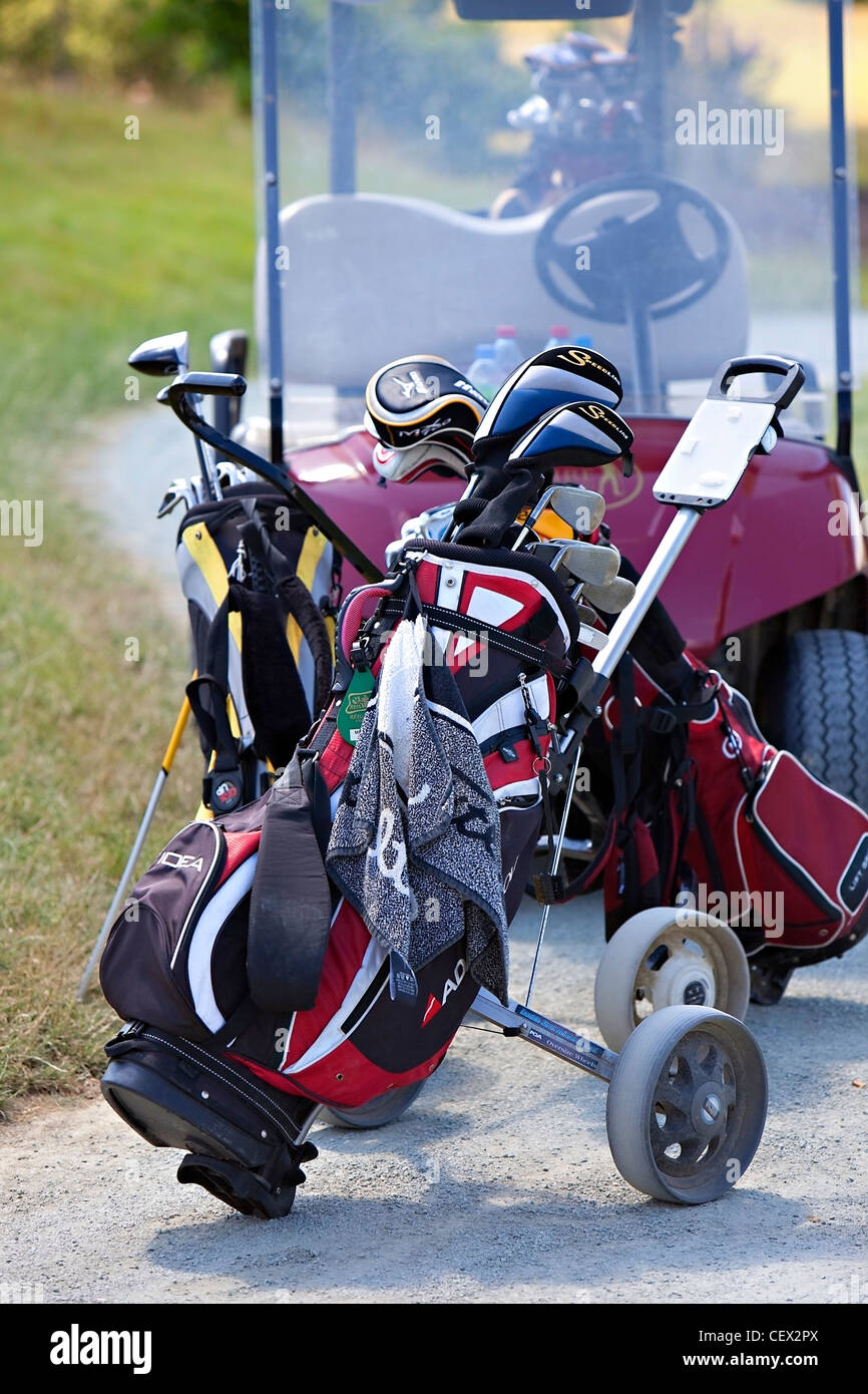 Clubs de Golf en carrito de golf y vehículo eléctrico en segundo plano. Foto de stock