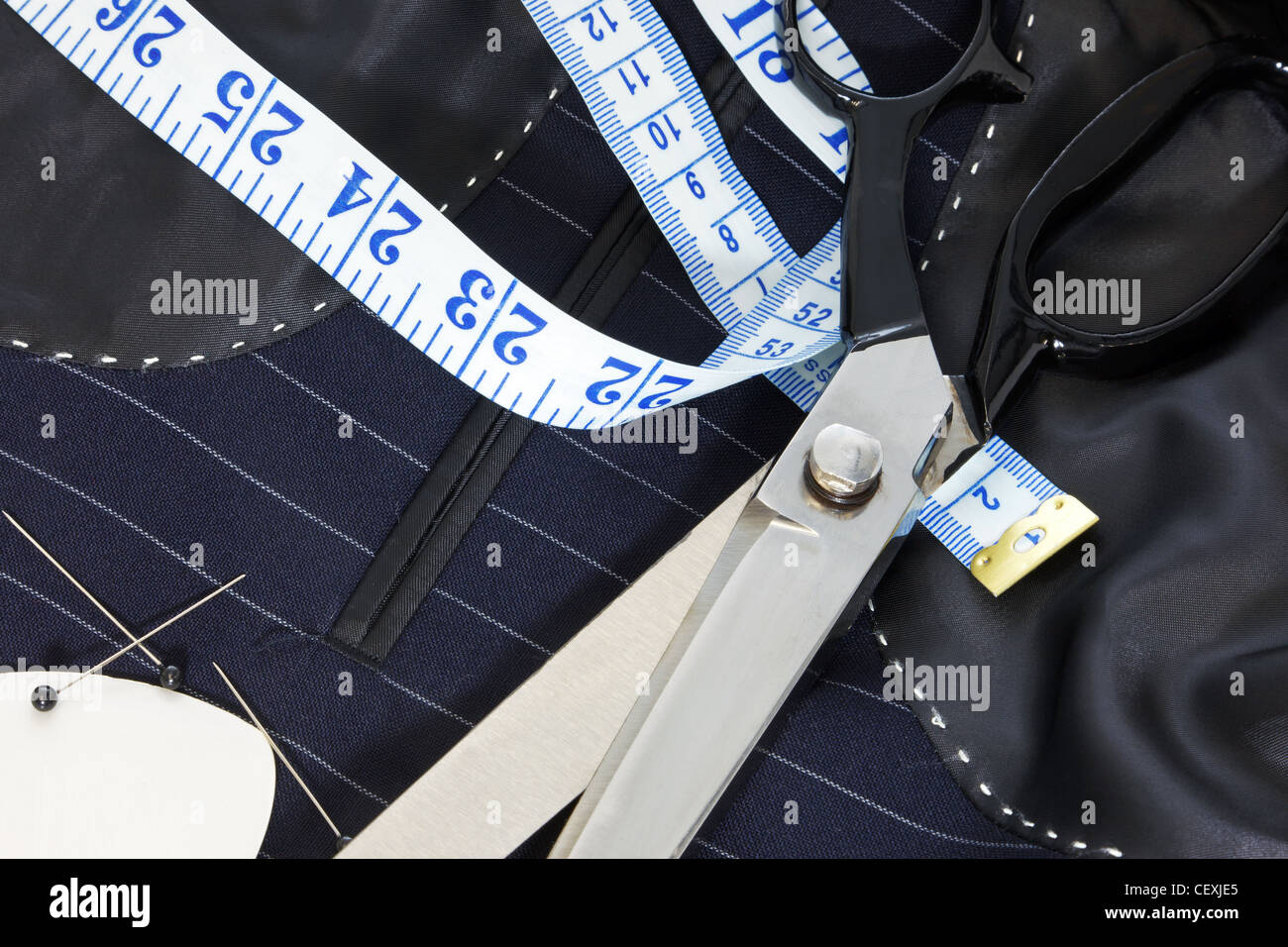 Todavía la vida foto del interior de una medida traje chaqueta con cosido a mano y tijeras, cinta métrica, tiza y pasadores. Foto de stock