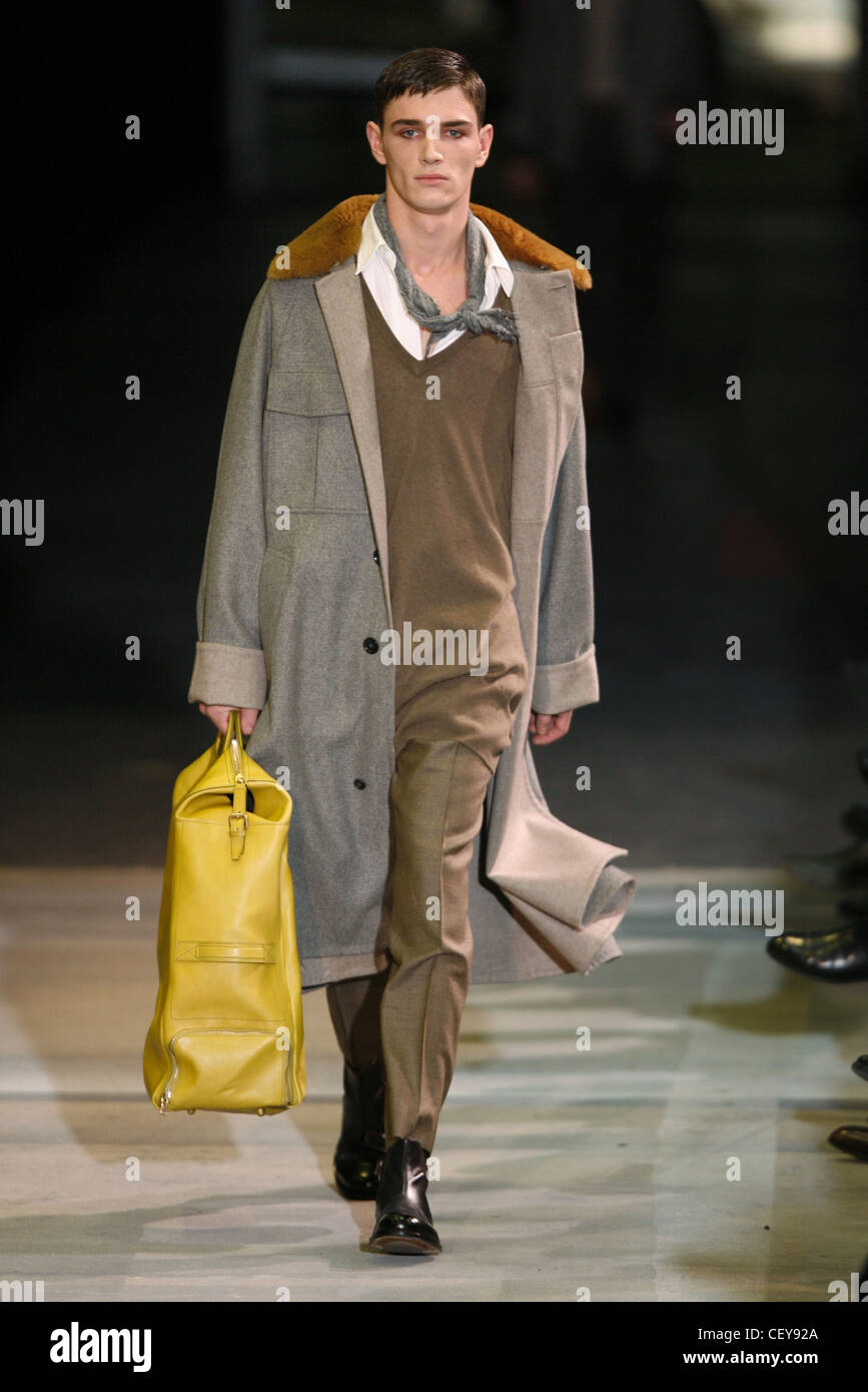 Yves Saint Laurent Paris listo para ponerse ropa de hombre Otoño Invierno  capas: modelo masculino llevar una maleta grande amarillo, vistiendo de  largo Fotografía de stock - Alamy