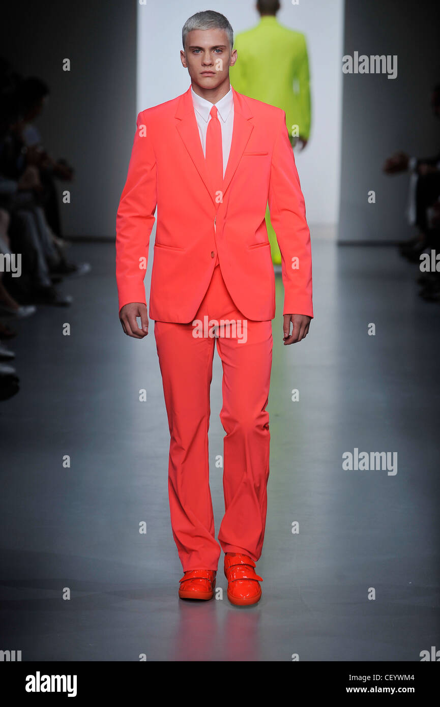 seguro raqueta representación Calvin Klein Milán listo para vestir Primavera Verano modelo vistiendo un  traje de color rosa salmón brillante coincidentes, camisa blanca y corbata  roja brillante Fotografía de stock - Alamy