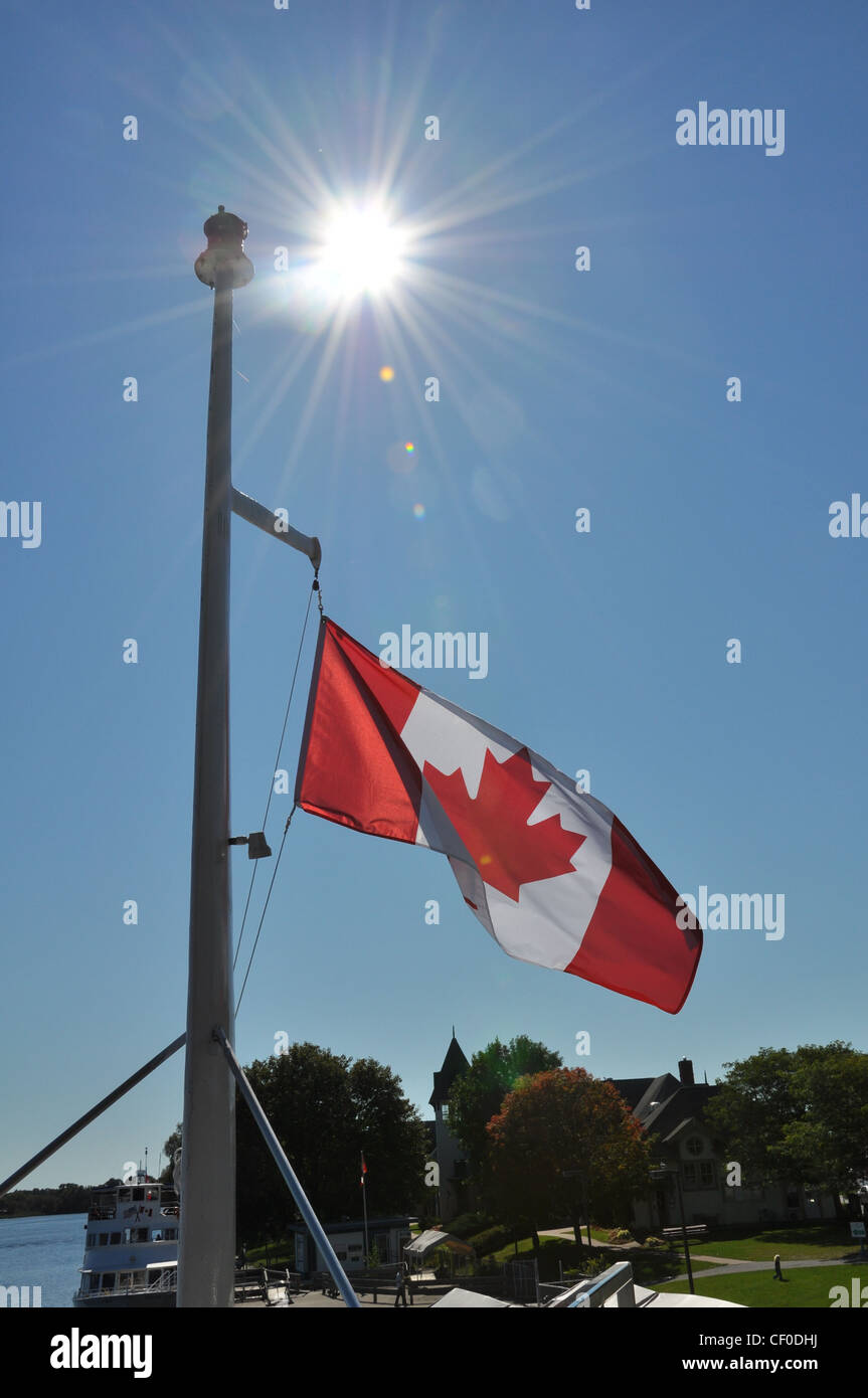 Canadá bandera bajo el telón de fondo de los claros cielos soleados Foto de stock