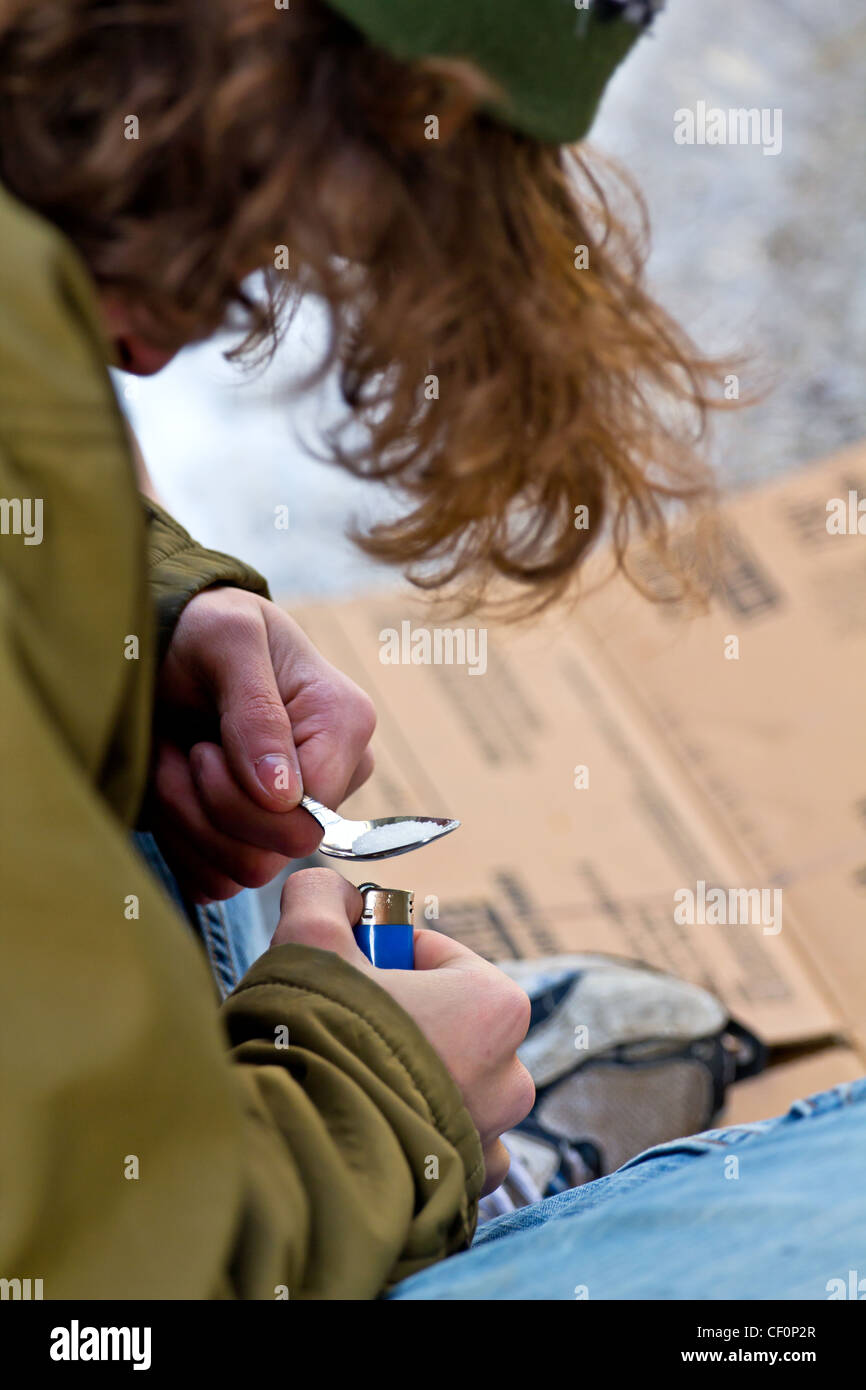 Drogadictos hombre sin hogar preparando heroína Foto de stock