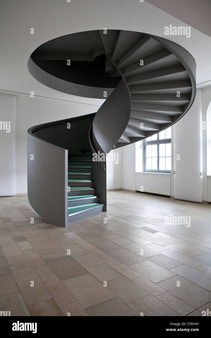 La moderna escalera en espiral dentro de un interior minimalista. Foto de stock