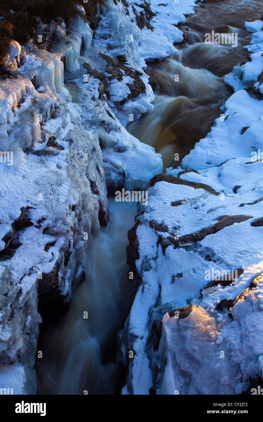 Cubiertas de hielo y nieve Linn de Dee, un tramo del río Dee, que fluye a través de un espectacular desfiladero natural cerca de Braemar. Foto de stock