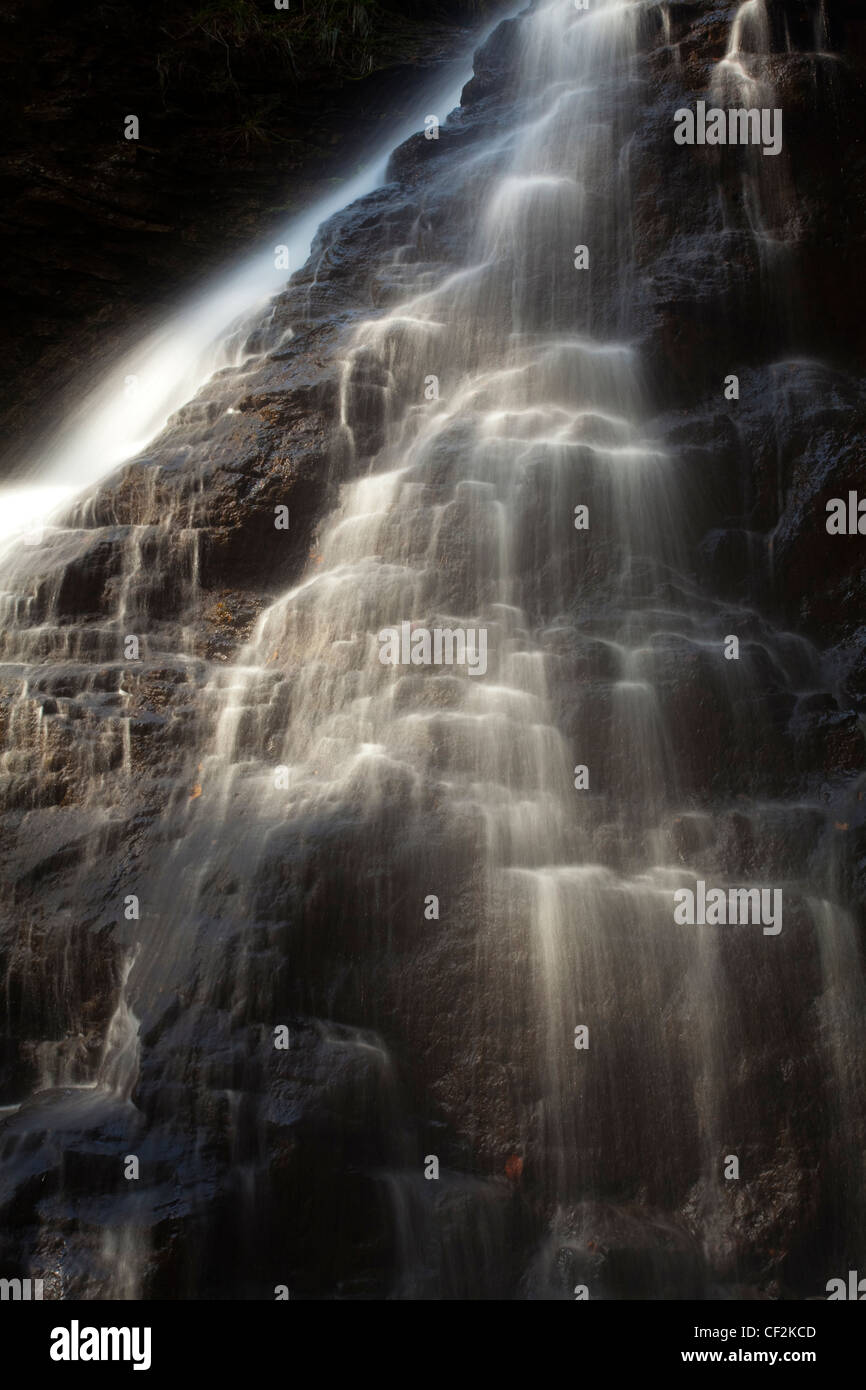 Hareshaw Linn es una espectacular cascada situada en un empinado cañón, que continúa fluyendo a través de un valle arbolado. Haresh Foto de stock