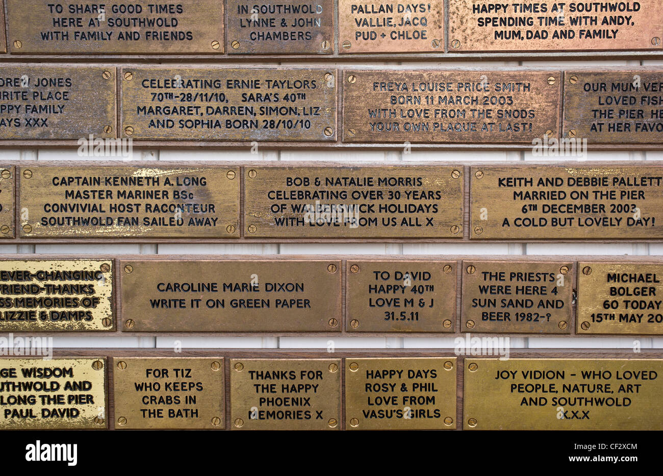 Las pequeñas placas de latón con mensajes personales sobre Southwold Pier. Foto de stock