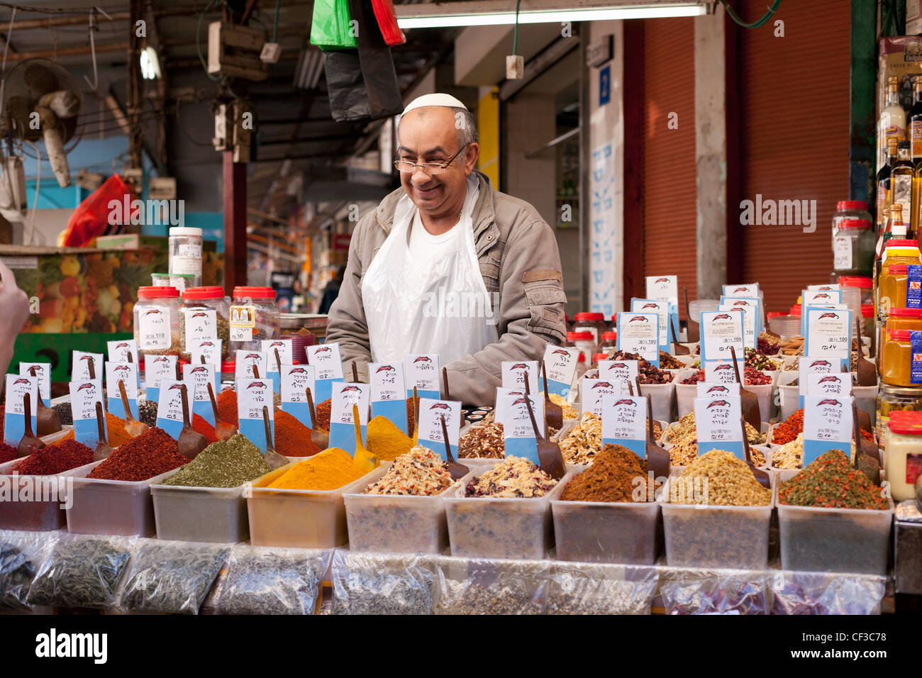 Israel, Tel Aviv, Carmel Market, hombre de mediana edad sonriente vendedor de especias en un mercado Foto de stock