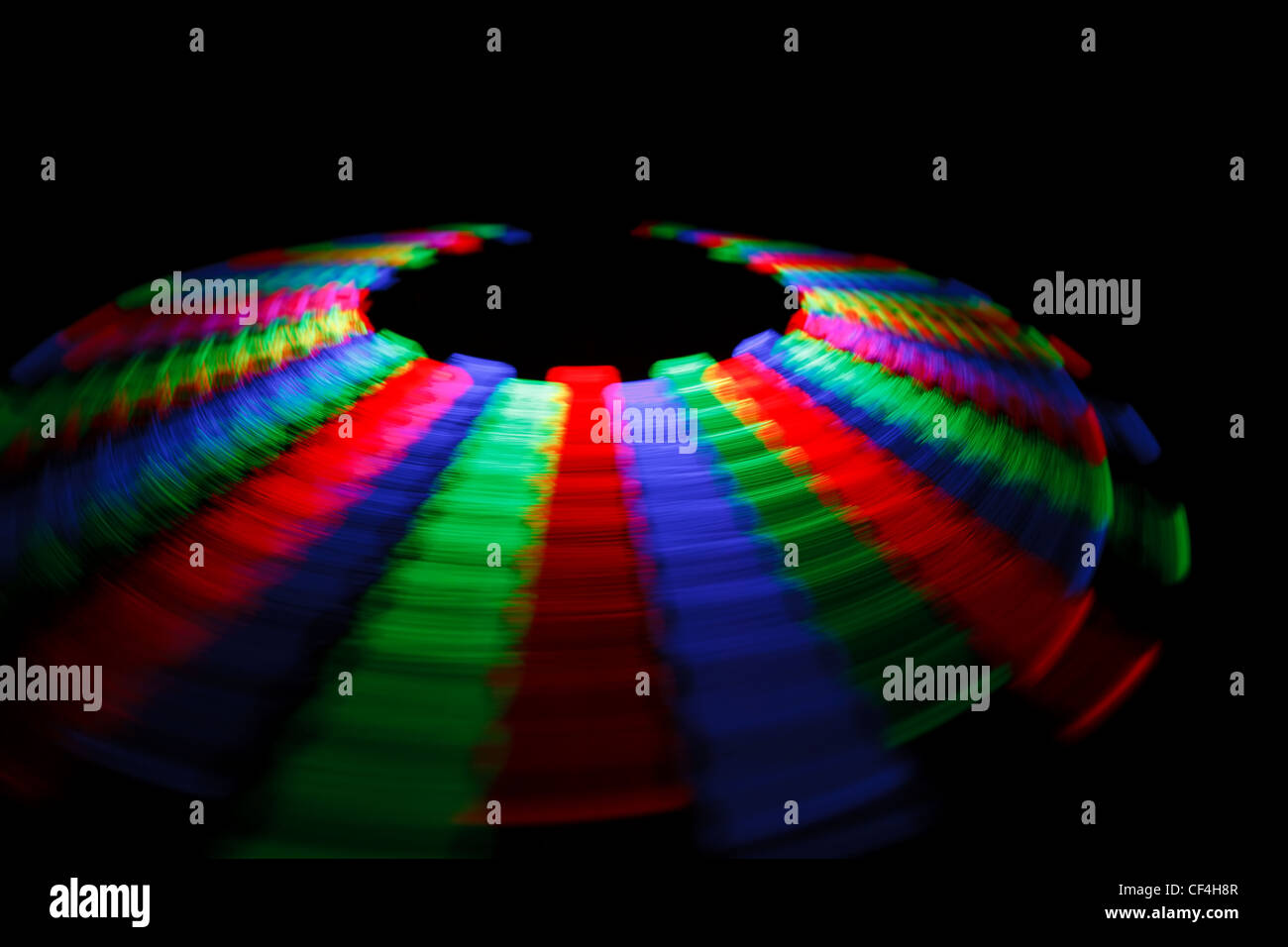 Traza colorido LED giratorio en forma de un disco sobre un fondo negro. Foto de stock