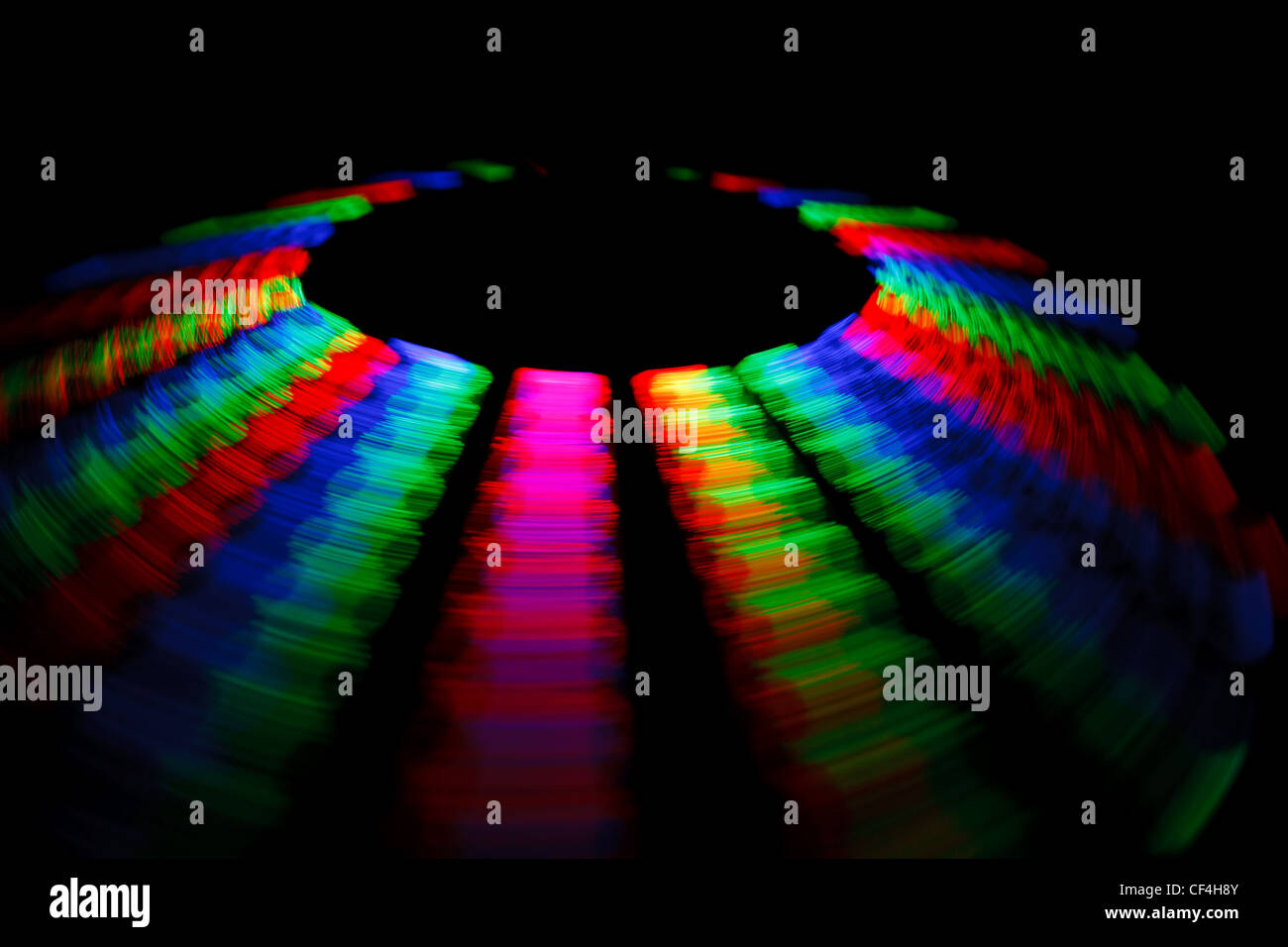 Traza colorido LED giratorio en forma de un disco sobre un fondo negro. Foto de stock