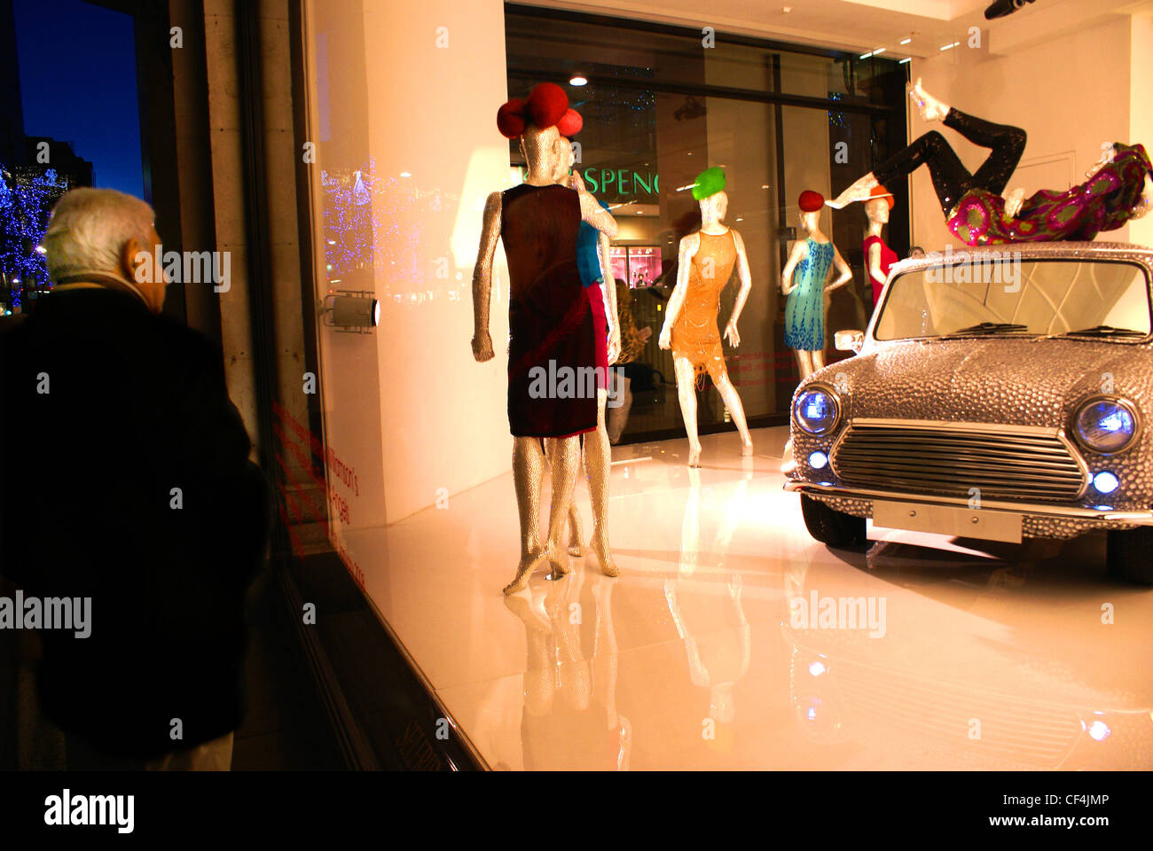 Un anciano mirando un escaparate de Navidad en Selfridges. Foto de stock