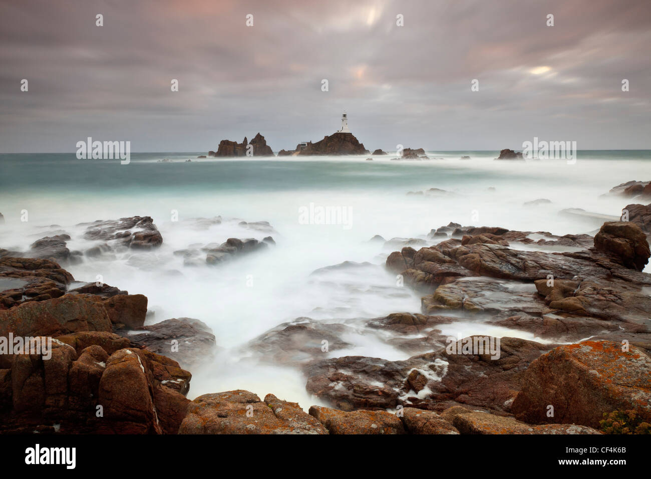El mar embravecido alrededor de la Corbiere Lighthouse al atardecer. El faro fue el primero en las Islas Británicas para ser construido de hormigón. Foto de stock