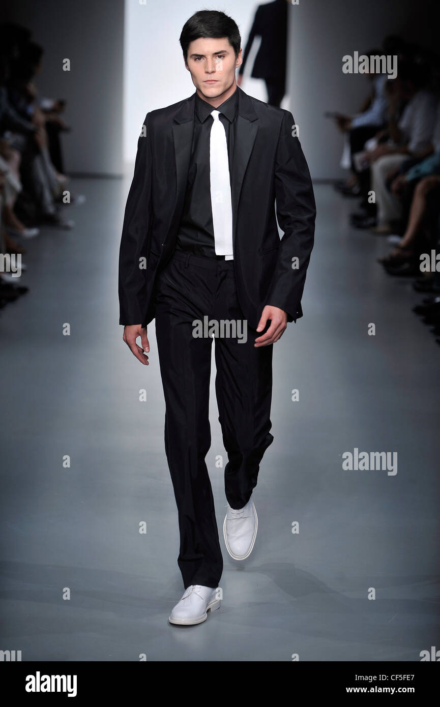 Calvin Klein Milán listo para vestir Primavera Verano modelo vistiendo un traje  negro de seda blanca, corbata de seda negro camisa blanca y patente  Fotografía de stock - Alamy