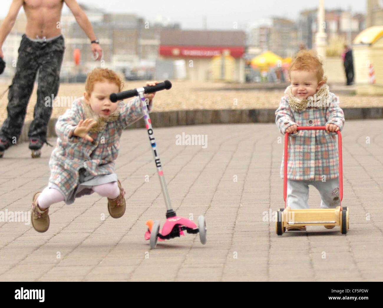 Las niñas pelo rojo rizado, vistiendo capas marcada coincidencia, Rosa  leotardos, pantalones vaqueros y las botas marrones, cayendo el Mini rosa  Fotografía de stock - Alamy